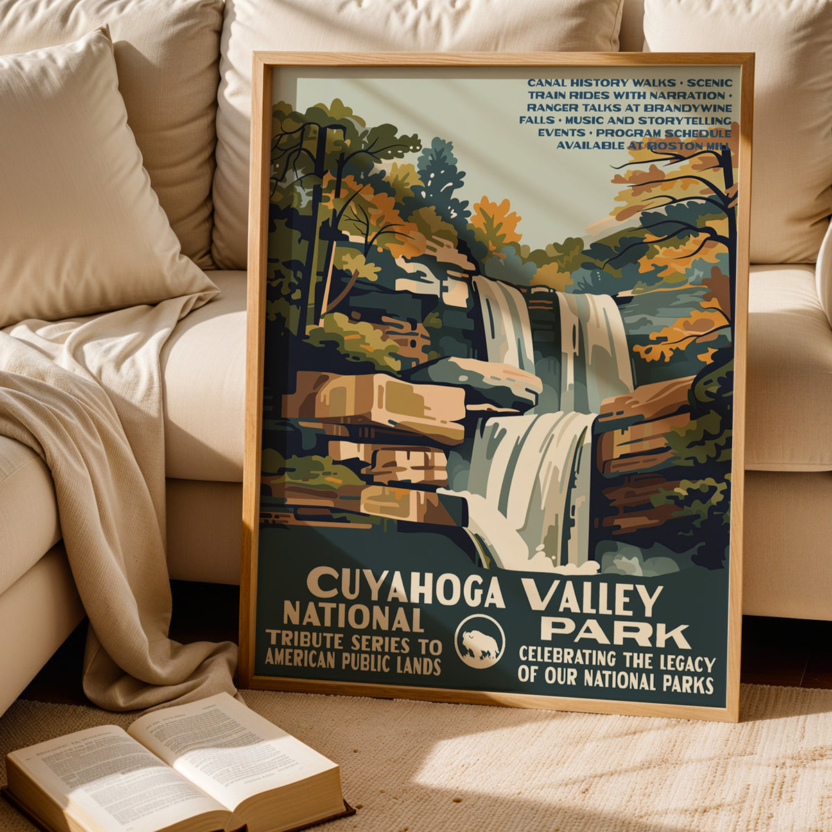 Cuyahoga Valley National Park WPA print leaning behind a cream sofa above an open book