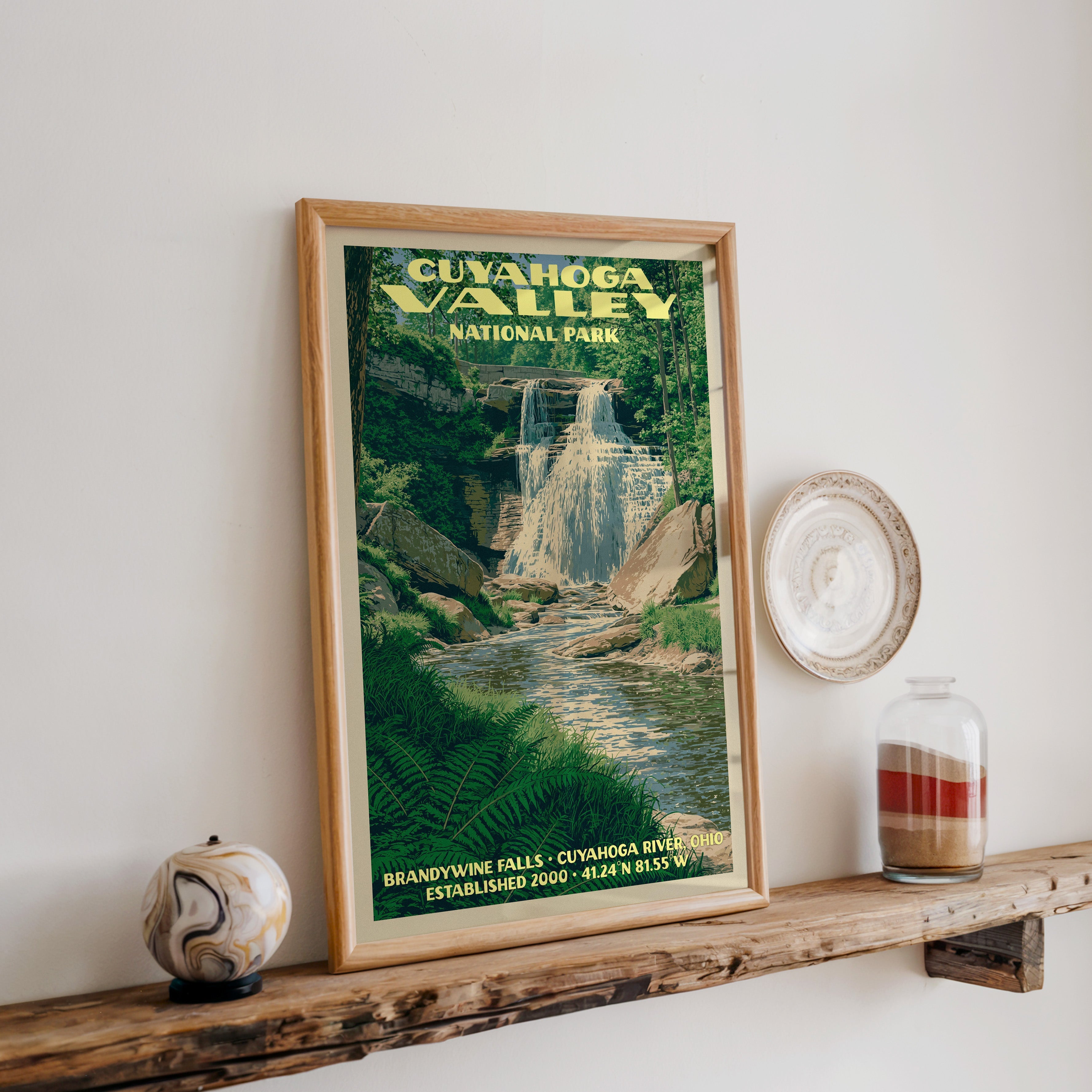 Cuyahoga Valley Brandywine Falls print in oak, leaning on a reclaimed wood ledge with a stone sphere and sand jar