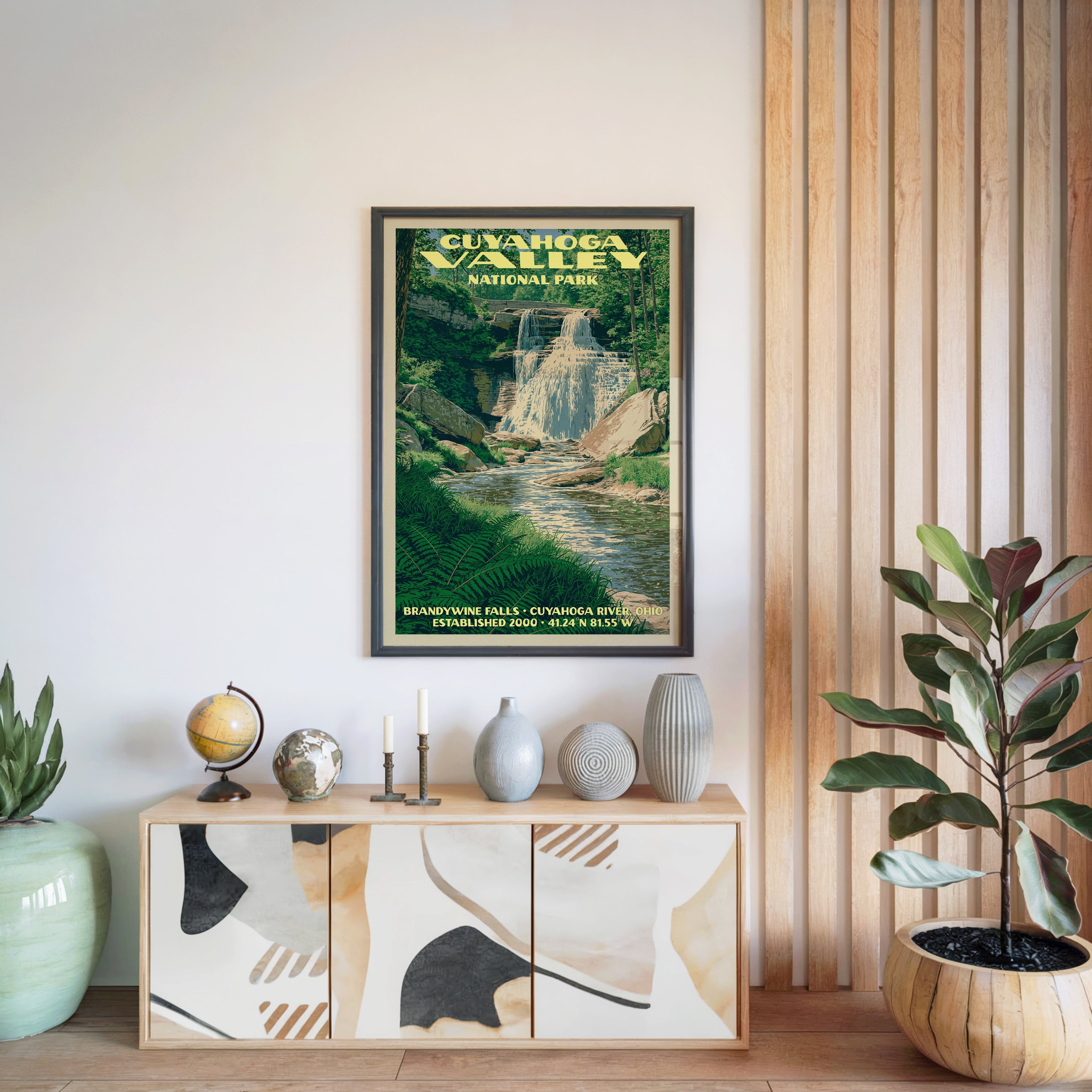 Cuyahoga Valley National Park poster in a black frame above a light wood sideboard by a slatted wall panel