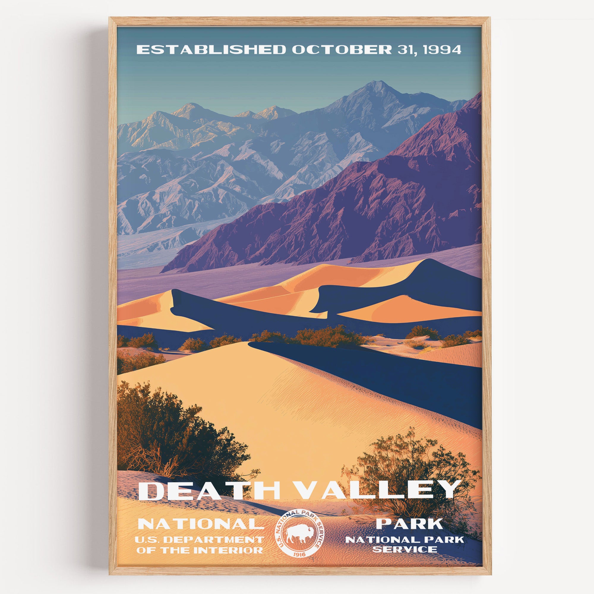 Death Valley National Park vintage travel poster in a wood frame, violet-shadowed sand dunes below distant desert mountains