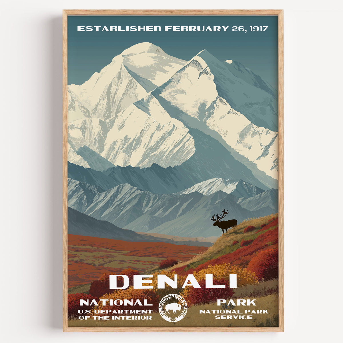 Denali National Park vintage travel poster in a wood frame, the snow-covered summit above an elk on the red autumn tundra