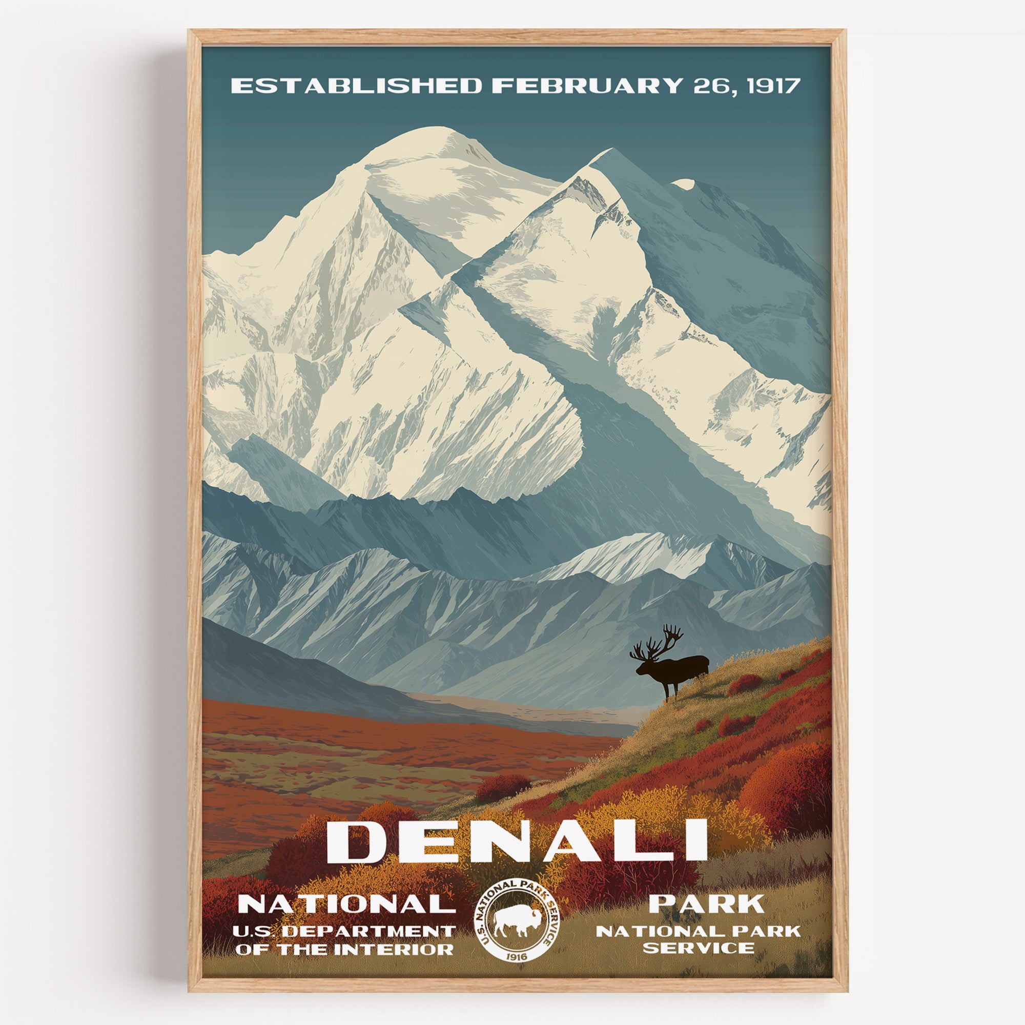 Denali National Park vintage travel poster in a wood frame, the snow-covered summit above an elk on the red autumn tundra