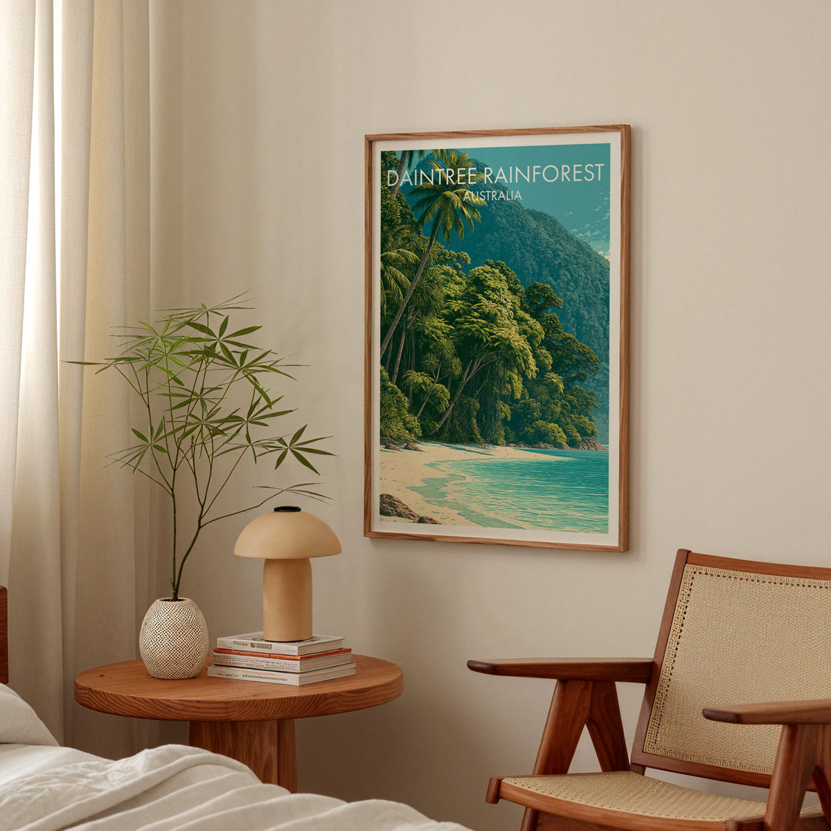 Jungle shoreline print in an oak frame in a bedroom above a round table with a mushroom lamp and cane chair