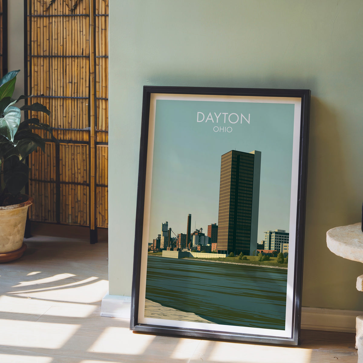 Dayton Ohio print in a black frame by a sage wall with a bamboo screen and a potted orchid