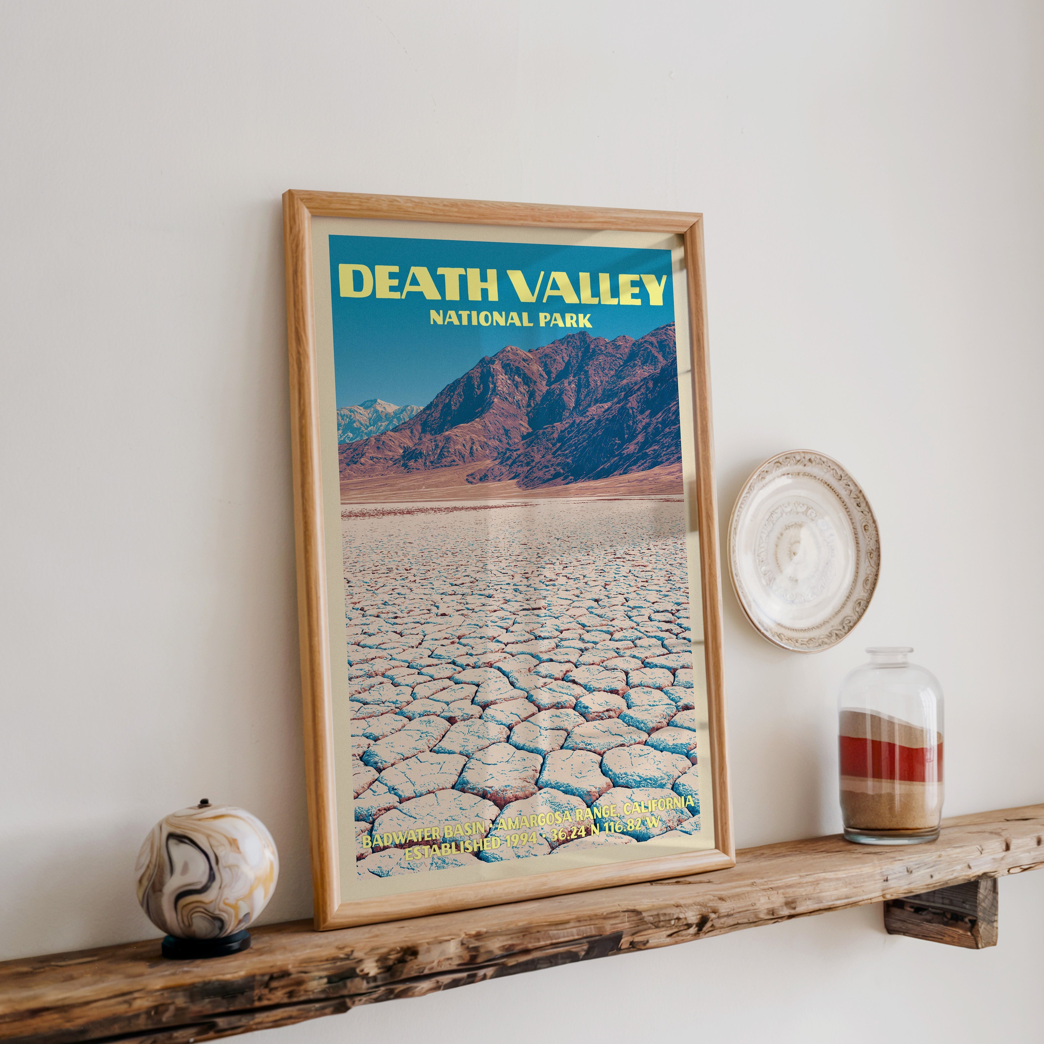 Death Valley Badwater Basin print in oak, leaning on a reclaimed wood ledge with a stone sphere and a sand jar
