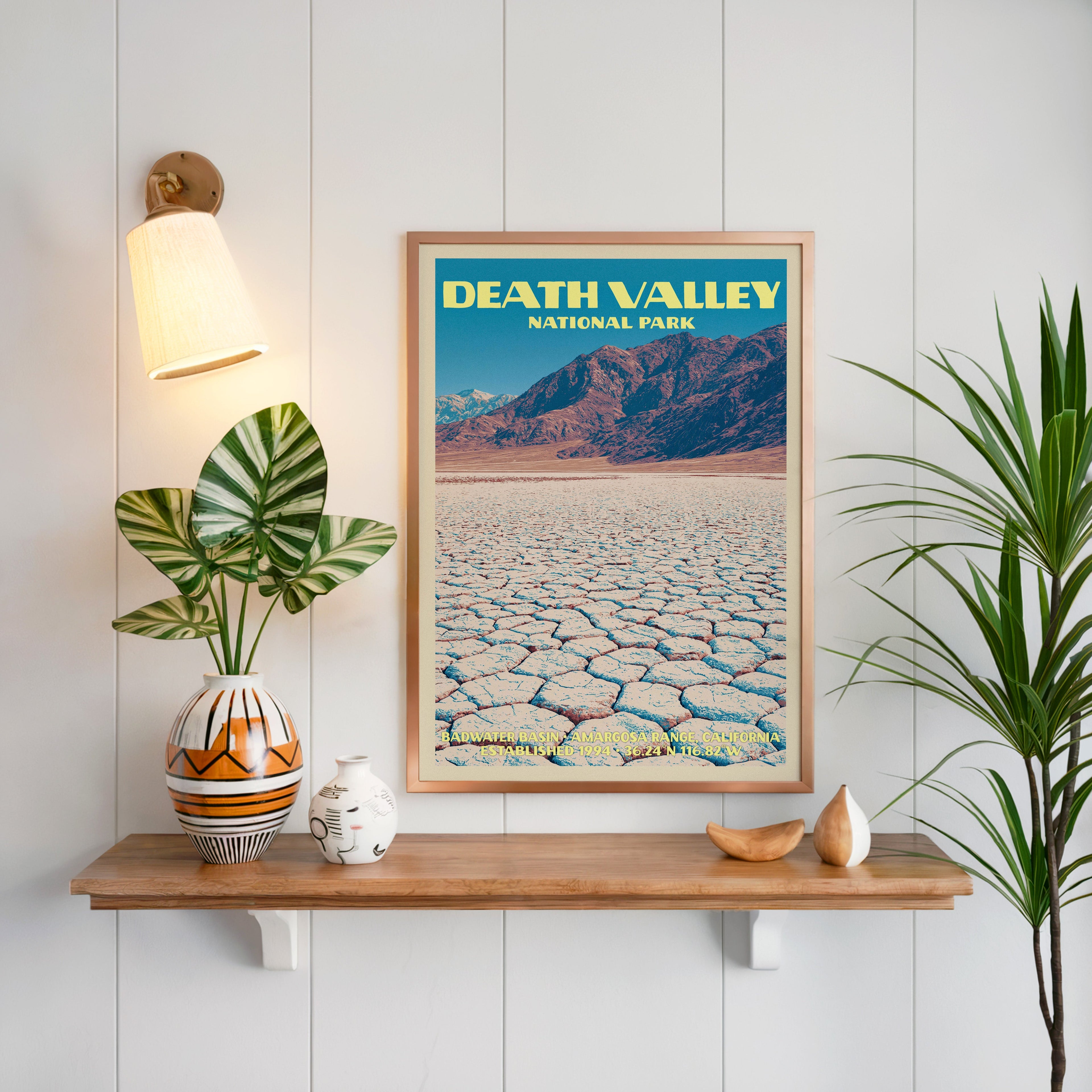 Badwater Basin Death Valley print framed on white panelling above an oak shelf with a patterned vase and sconce