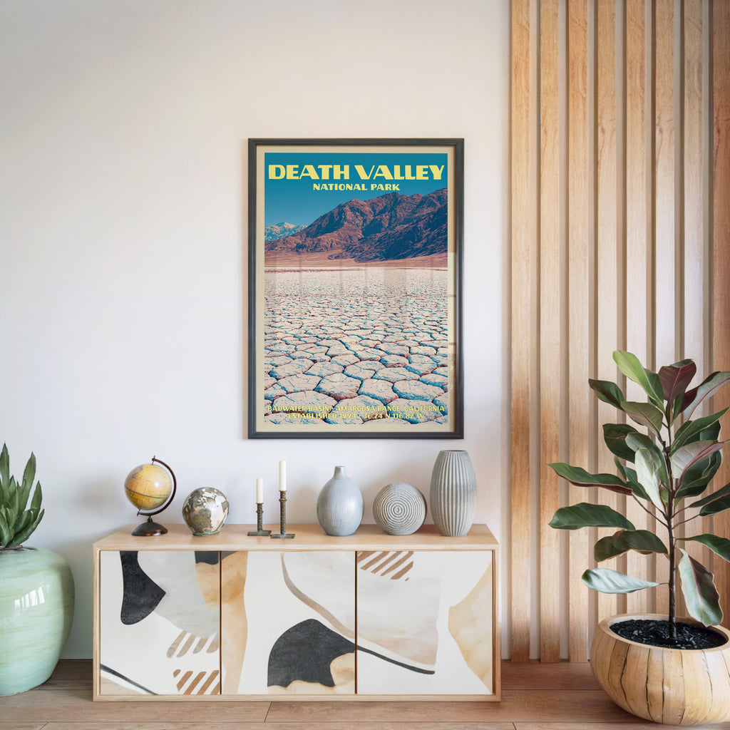 Death Valley National Park poster in a black frame above a light wood sideboard by a slatted wall panel