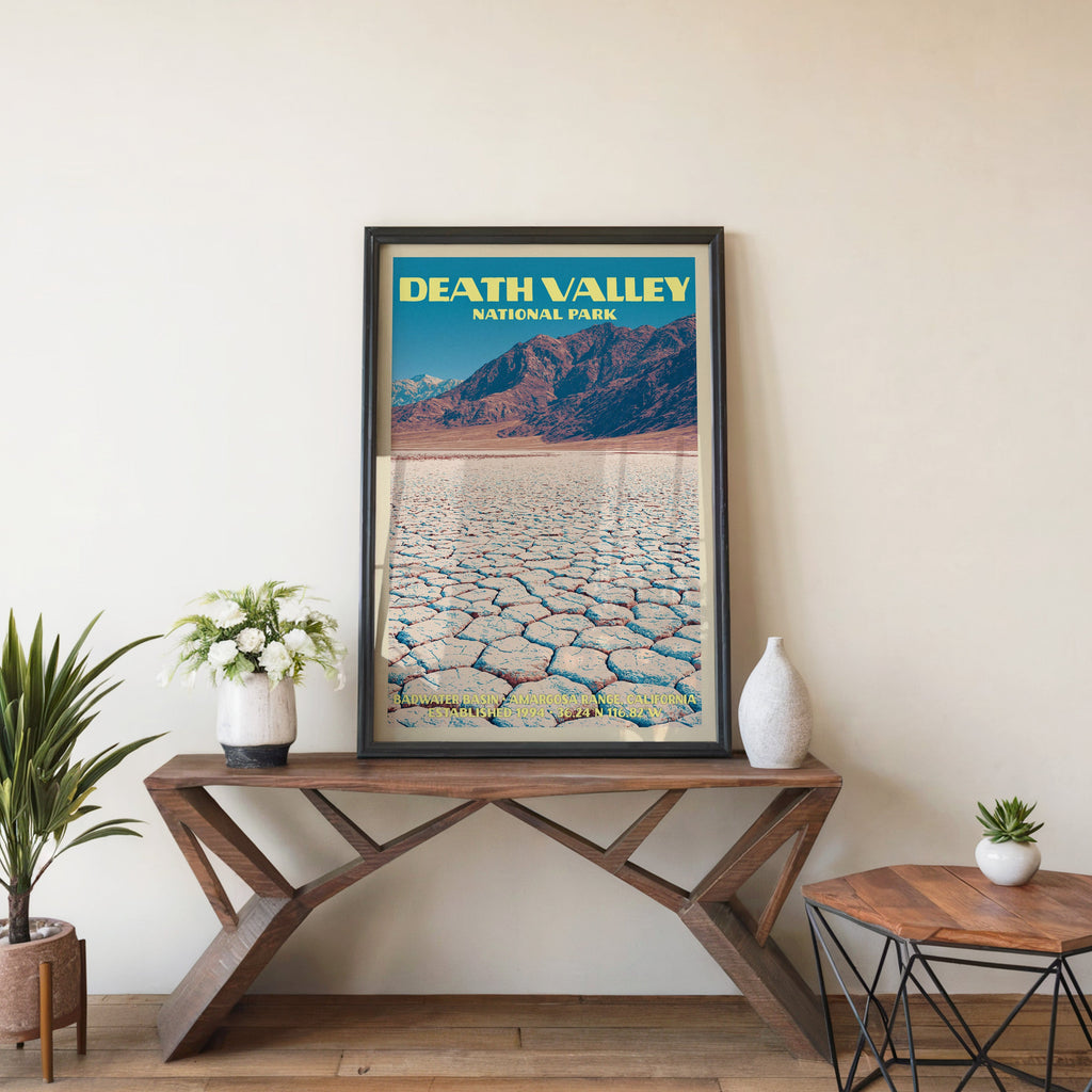 Death Valley Badwater Basin wall art in black, leaning on a walnut console with white anemones and a vase