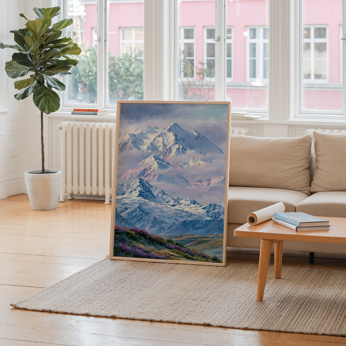 Denali National Park watercolor art print leaning against a living room wall beside a linen sofa and coffee table