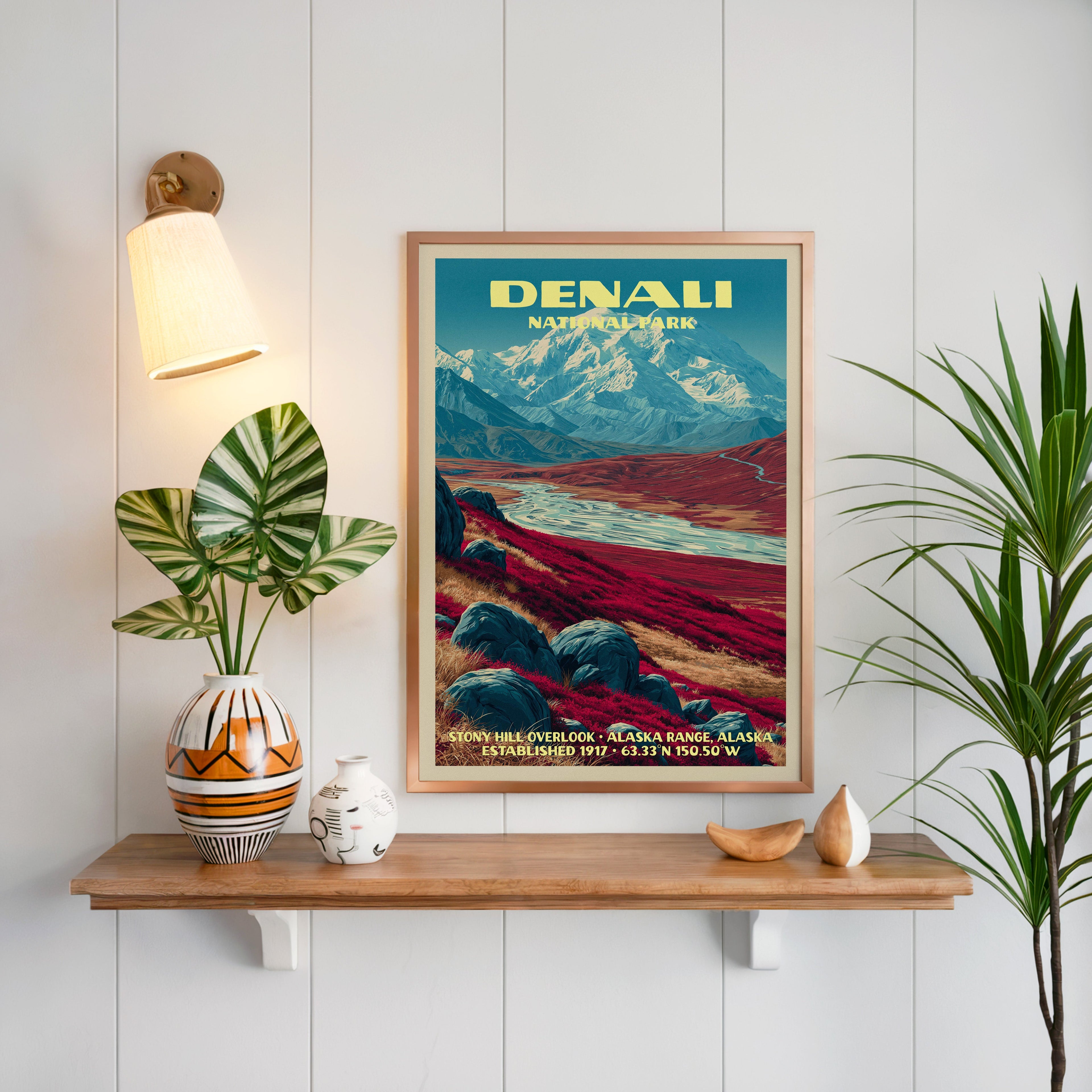 Stony Hill Overlook Denali print framed on white panelling above an oak shelf with a patterned vase and sconce