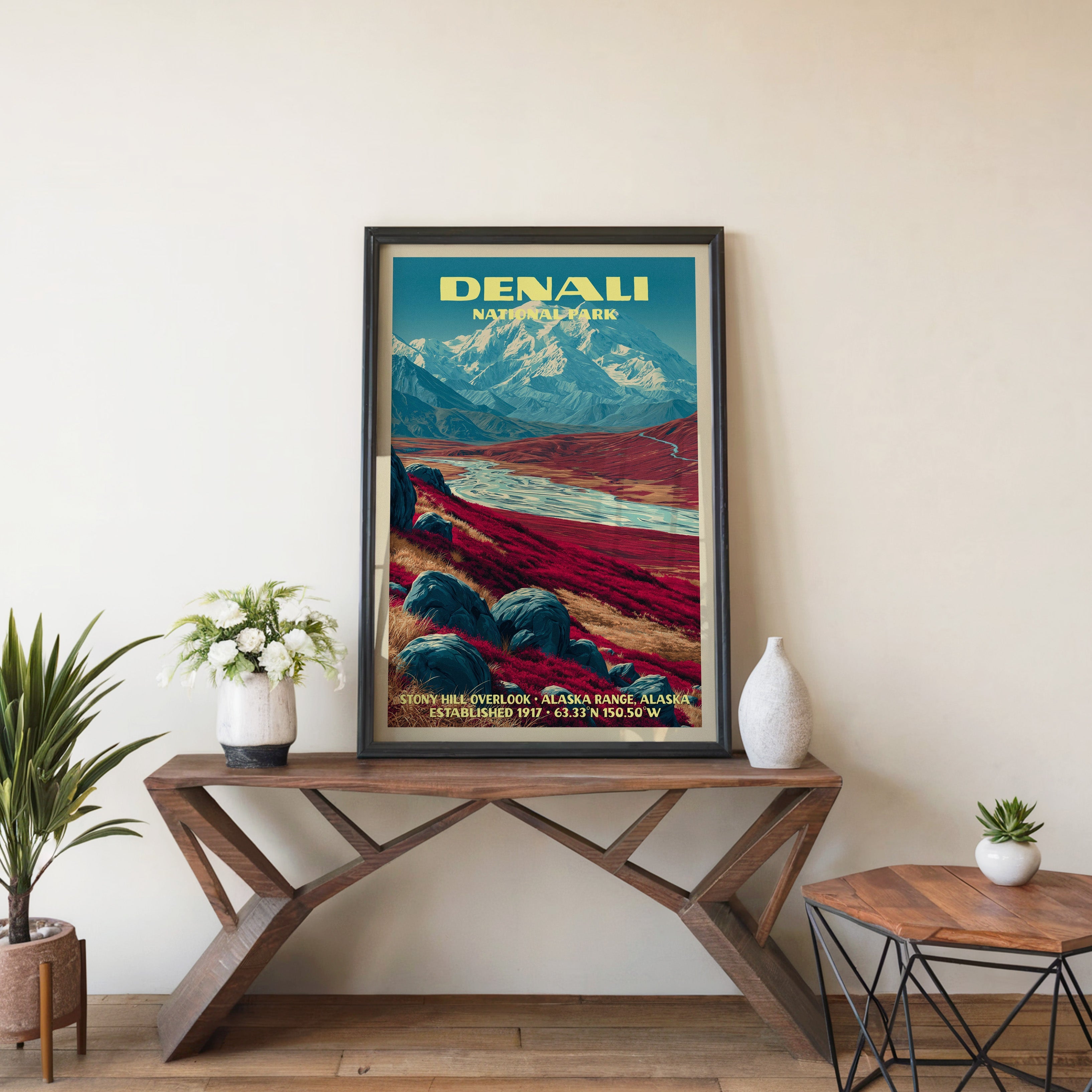 Denali Stony Hill Overlook wall art in black, leaning on a walnut console with white anemones and a vase