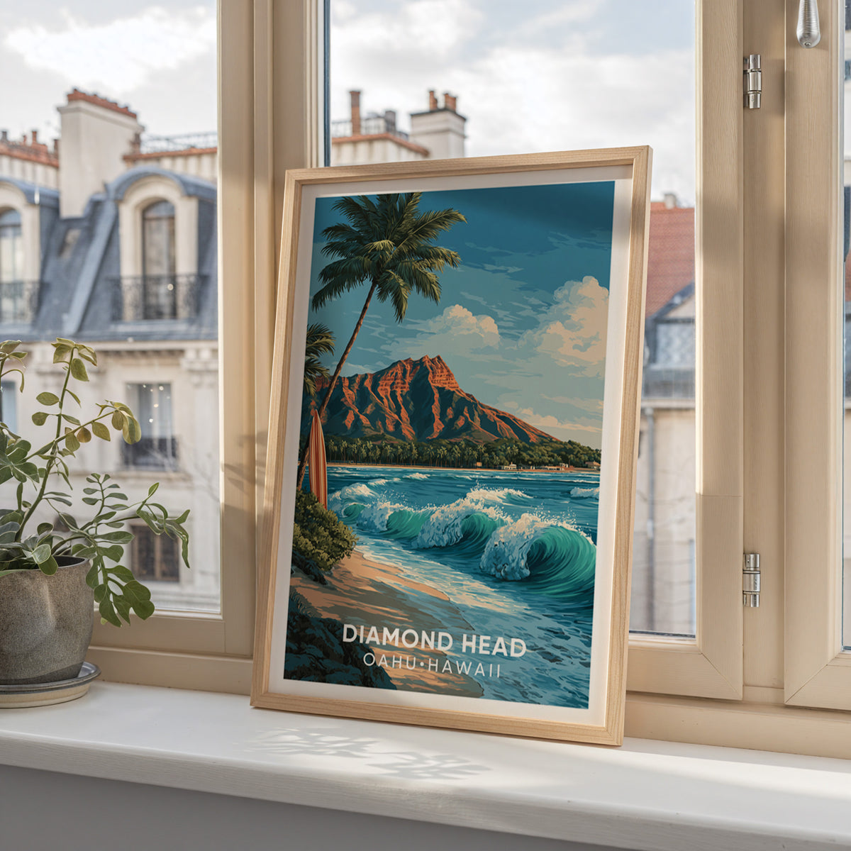Diamond Head framed print on a windowsill with Paris mansard rooftops and a small potted plant behind.