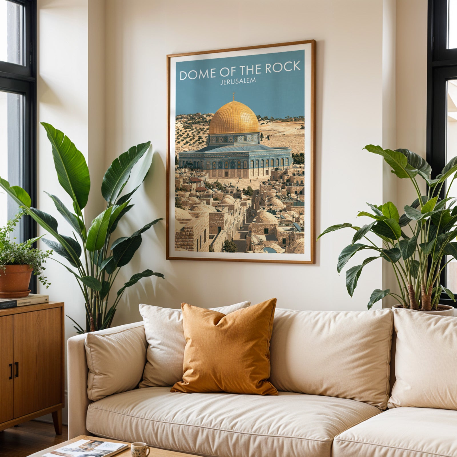 Framed Dome of the Rock Jerusalem wall art hanging above a cream sofa in a bright living room with tropical plants