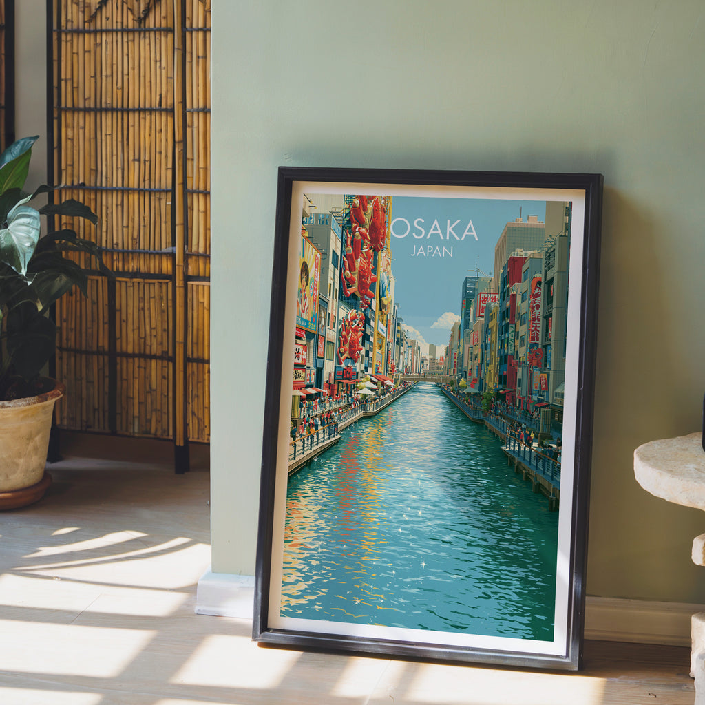 Dotonbori Osaka Japan wall art in a black frame leaning against a sage green wall beside a bamboo screen