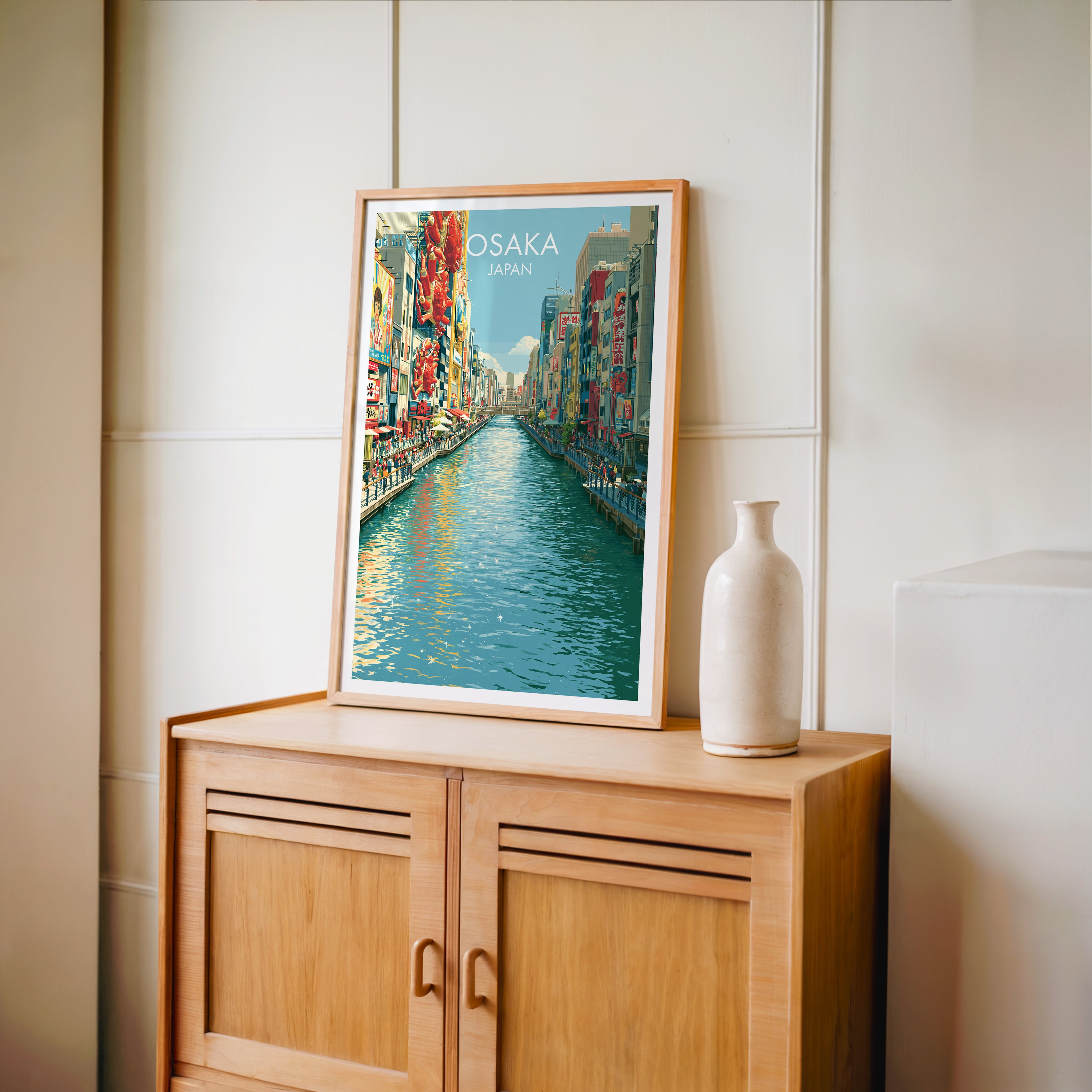 Small Dotonbori Osaka Japan travel poster in an oak frame on a mid-century sideboard with a ceramic vase