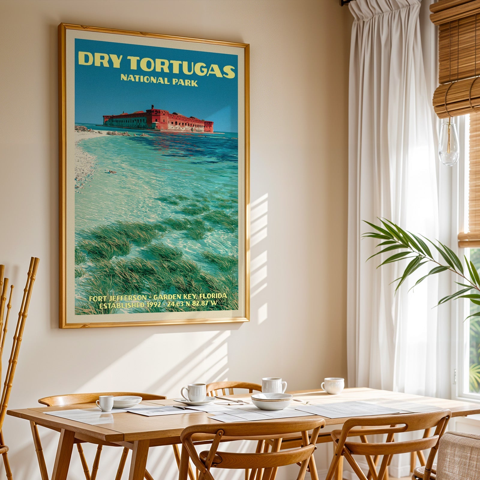 Dry Tortugas National Park print in gold above a light oak dining table by a curtained window