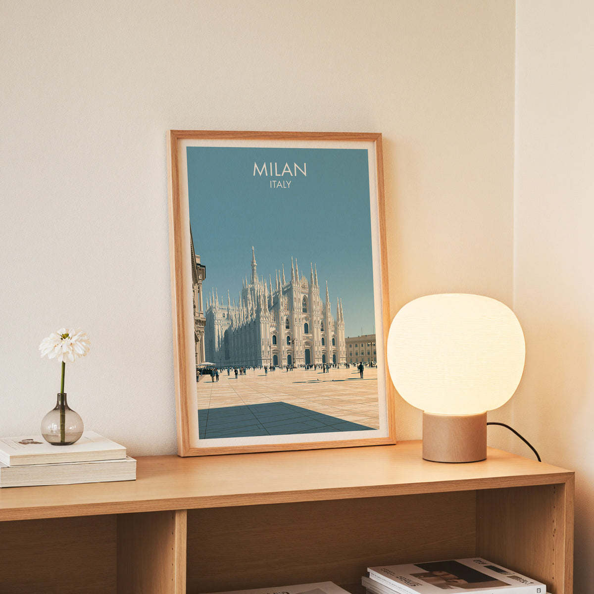 Milan cathedral wall art, slim oak frame on an oak console beside a daisy in a glass bottle