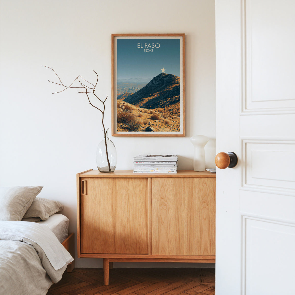 El Paso canvas art in an oak frame on a sideboard with dried branches in a glass vase