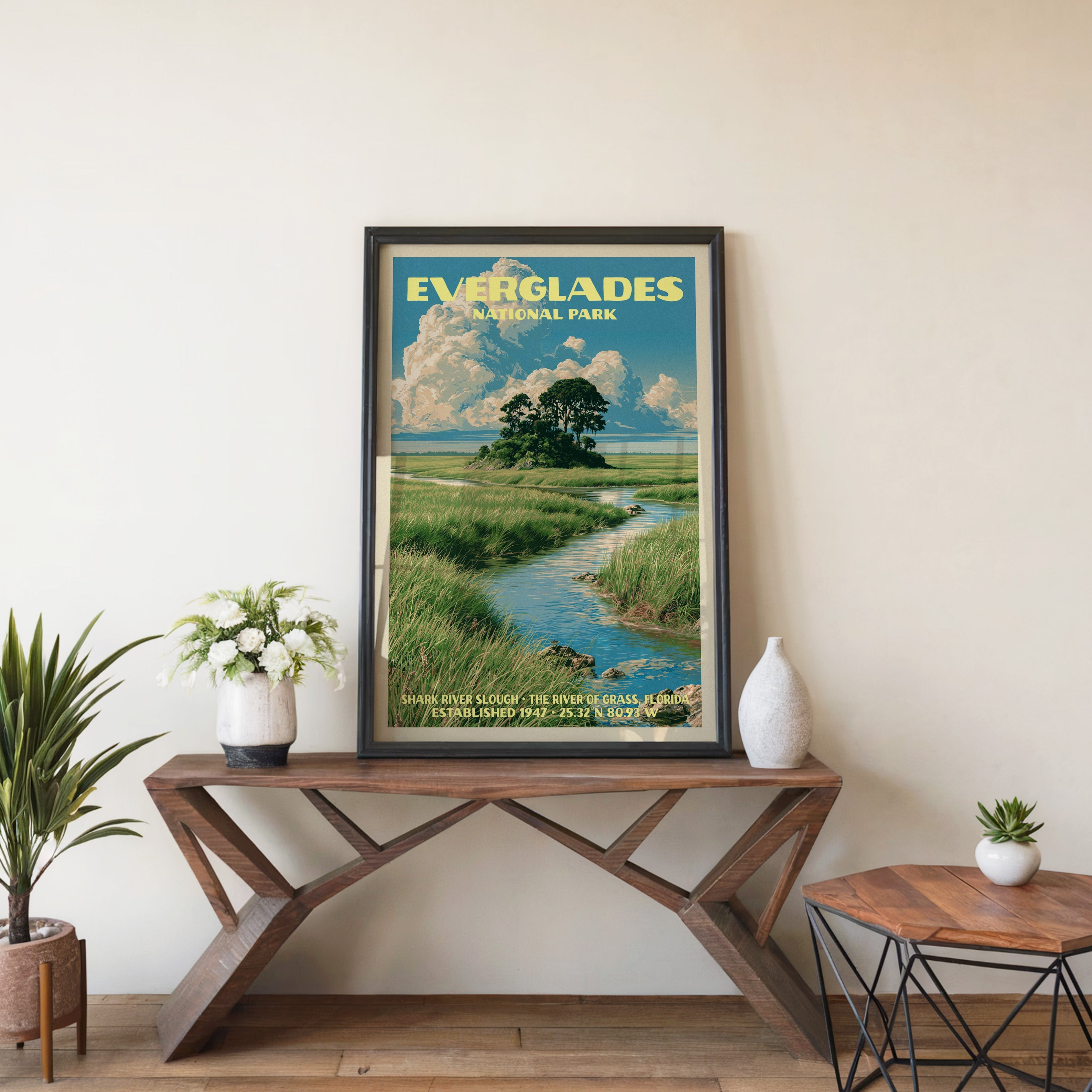 Everglades Shark River Slough wall art in black, leaning on a walnut console with white anemones in a vase