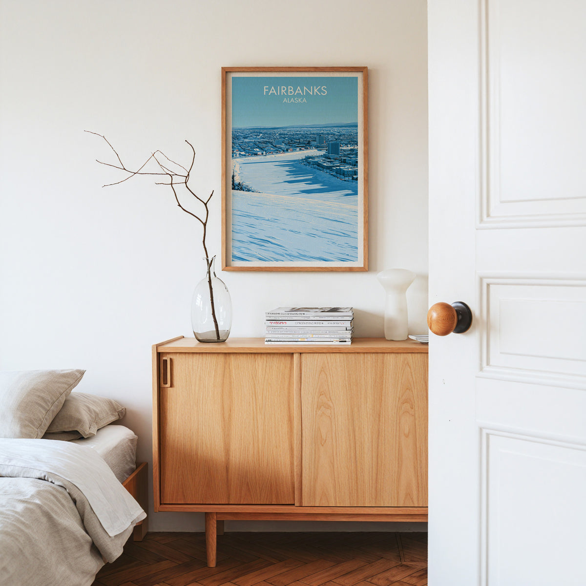 Fairbanks travel poster in an oak frame on a sideboard with dried branches in a glass vase