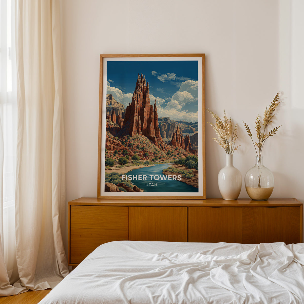 Fisher Towers print in an oak frame on a teak bedside sideboard with dried pampas in two white vases.