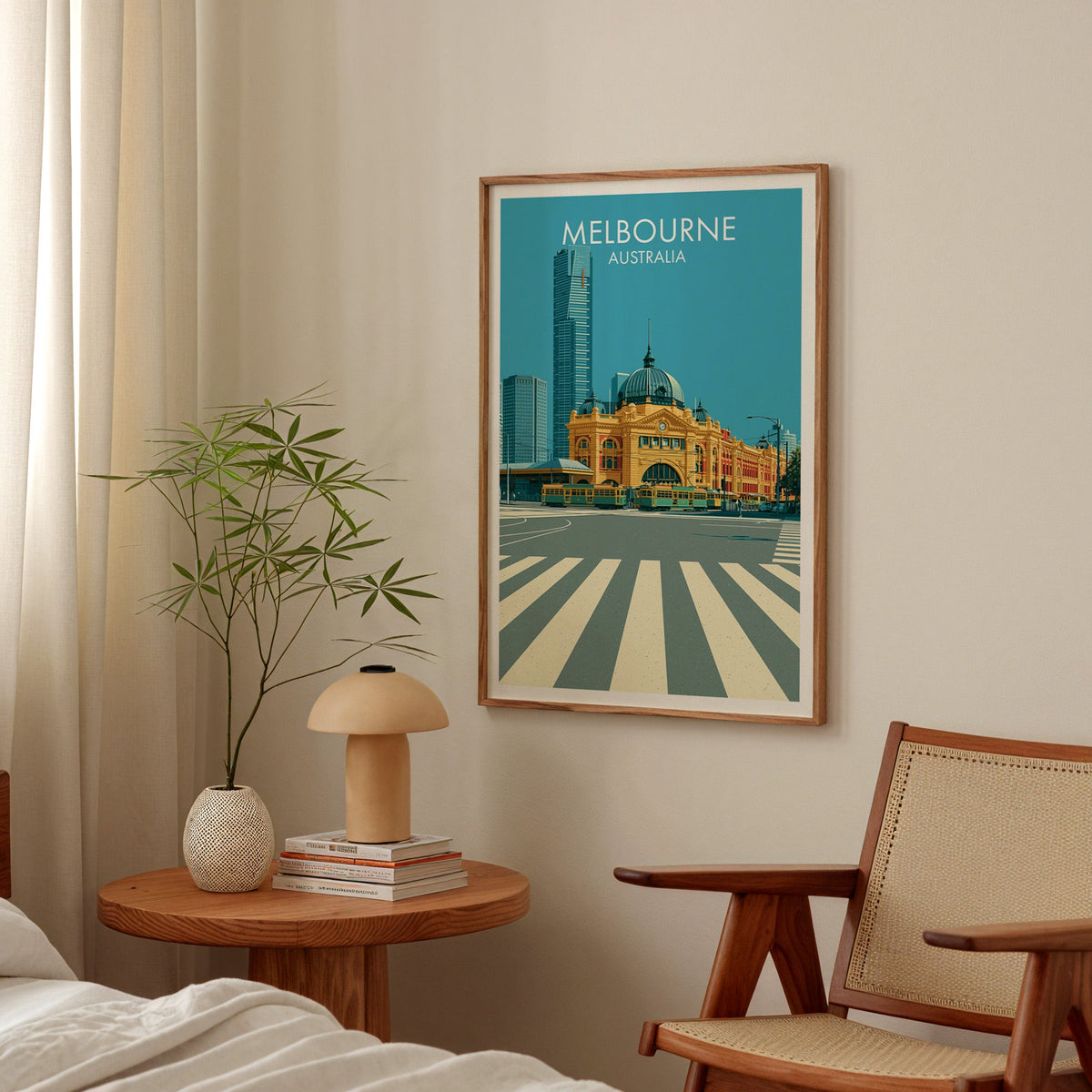 Melbourne bedroom print in an oak frame above a round bedside table with a mushroom lamp and bamboo stems