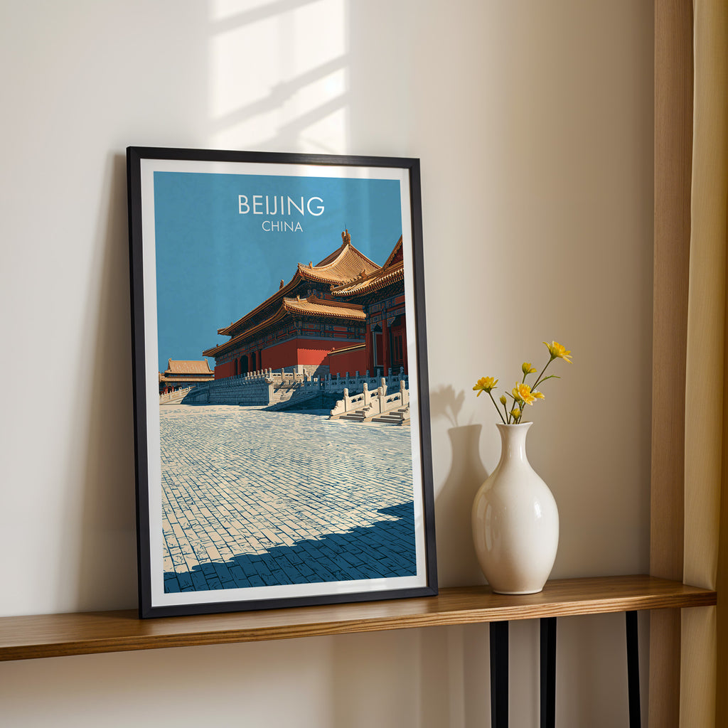 Black framed Forbidden City Beijing China print on a narrow hallway console in sunlight, styled with yellow flowers