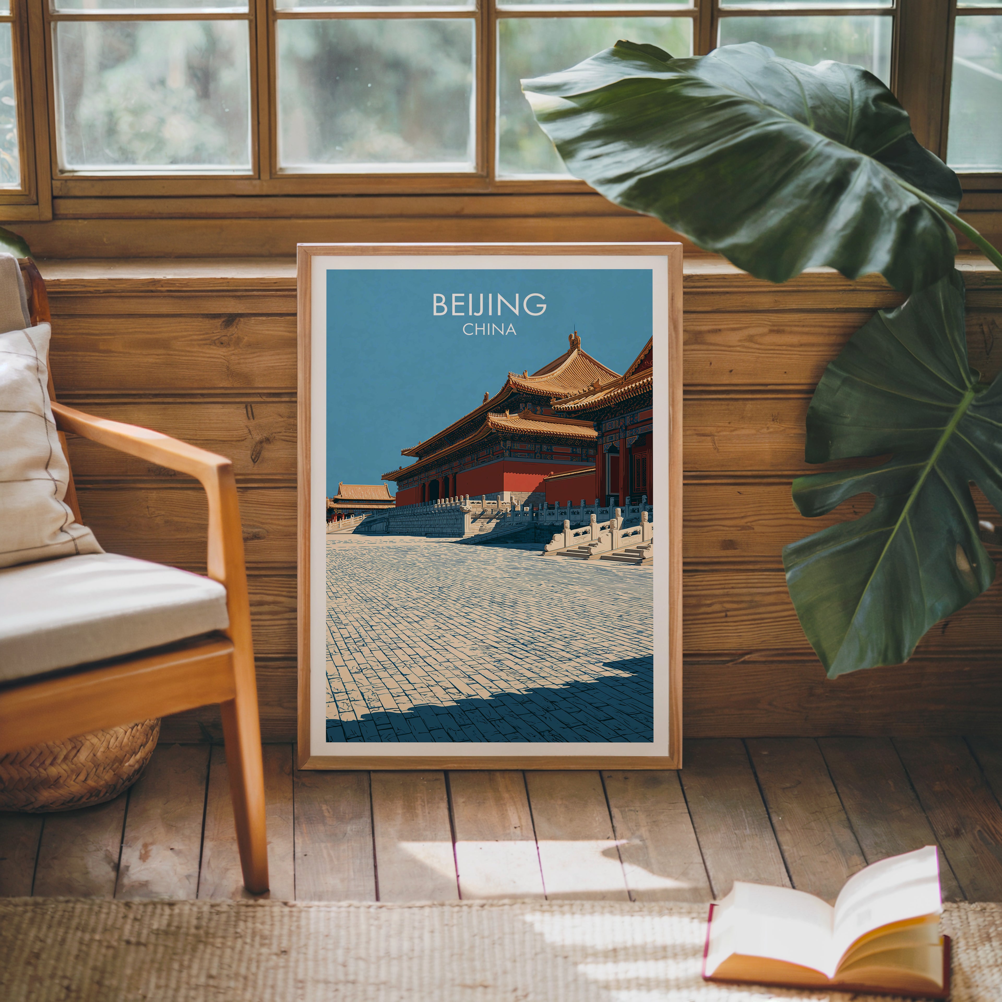 Framed Forbidden City Beijing China poster leaning against a timber cabin wall with monstera leaves and an open book