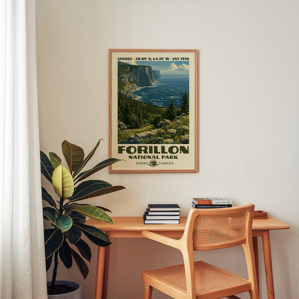 Forillon Canada vintage poster in an oak frame above a wood desk with a cane chair