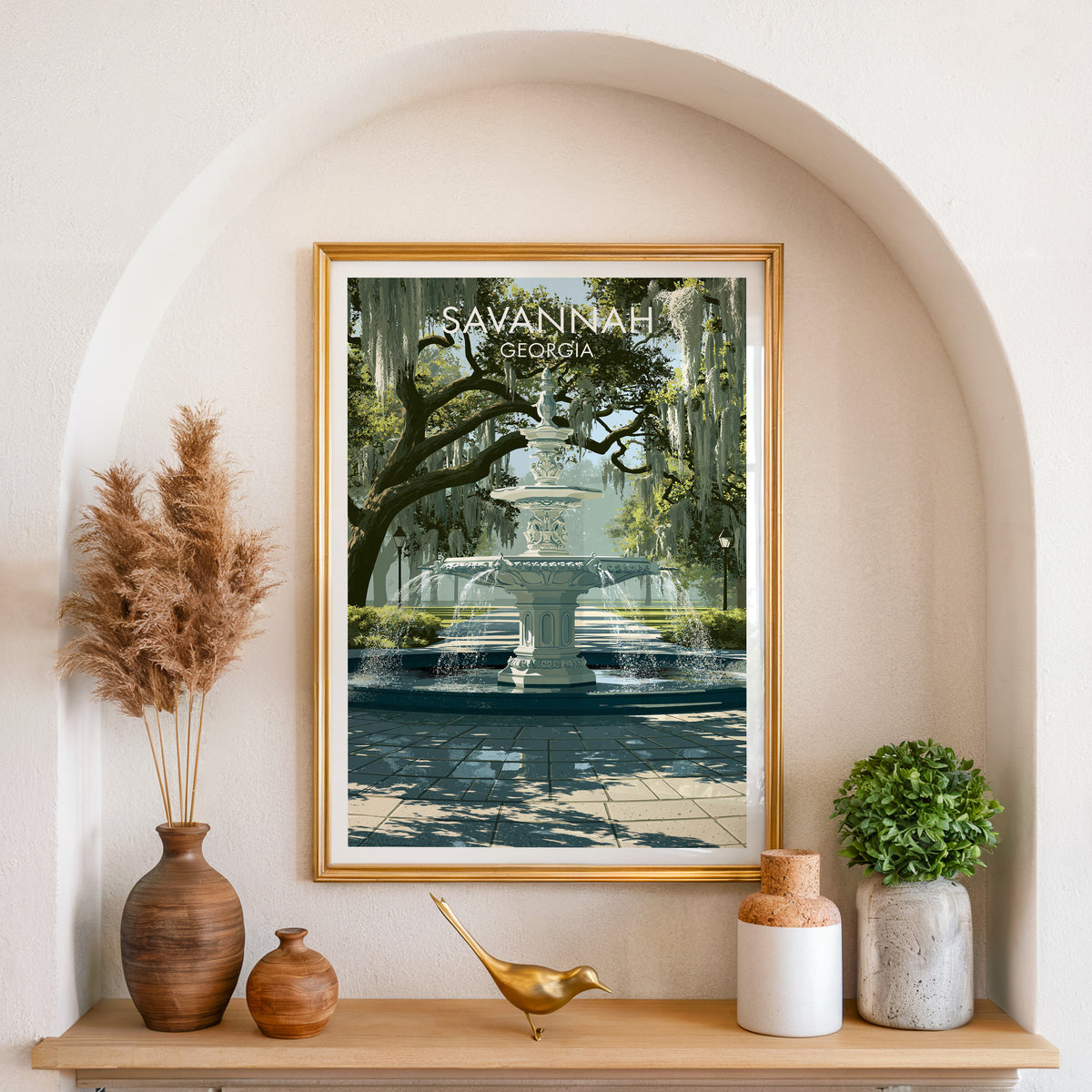 Forsyth Park canvas art in a gold frame set in an arched niche with pampas grass and a brass bird.