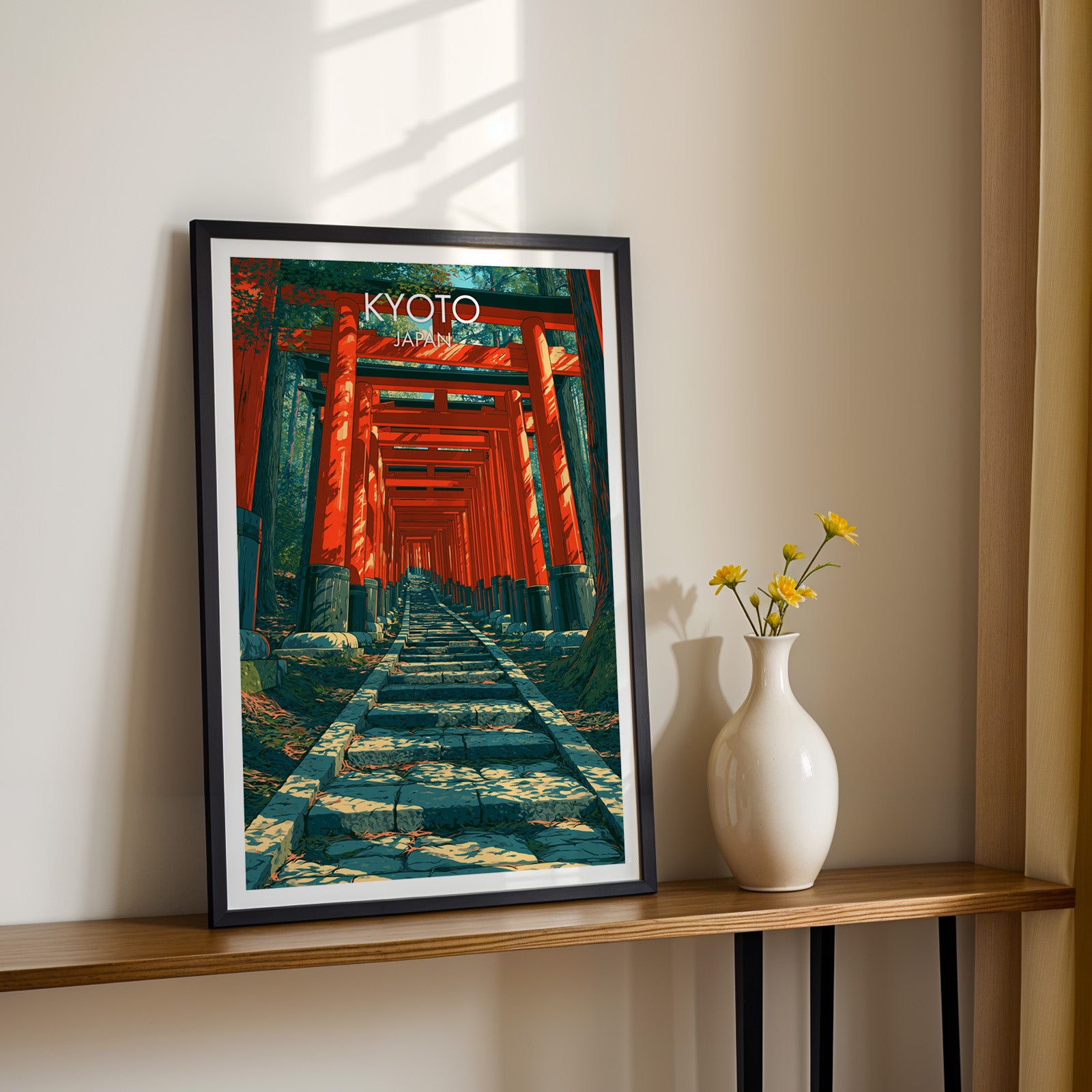 Black framed Fushimi Inari Kyoto Japan print on a narrow hallway console in sunlight, styled with yellow flowers