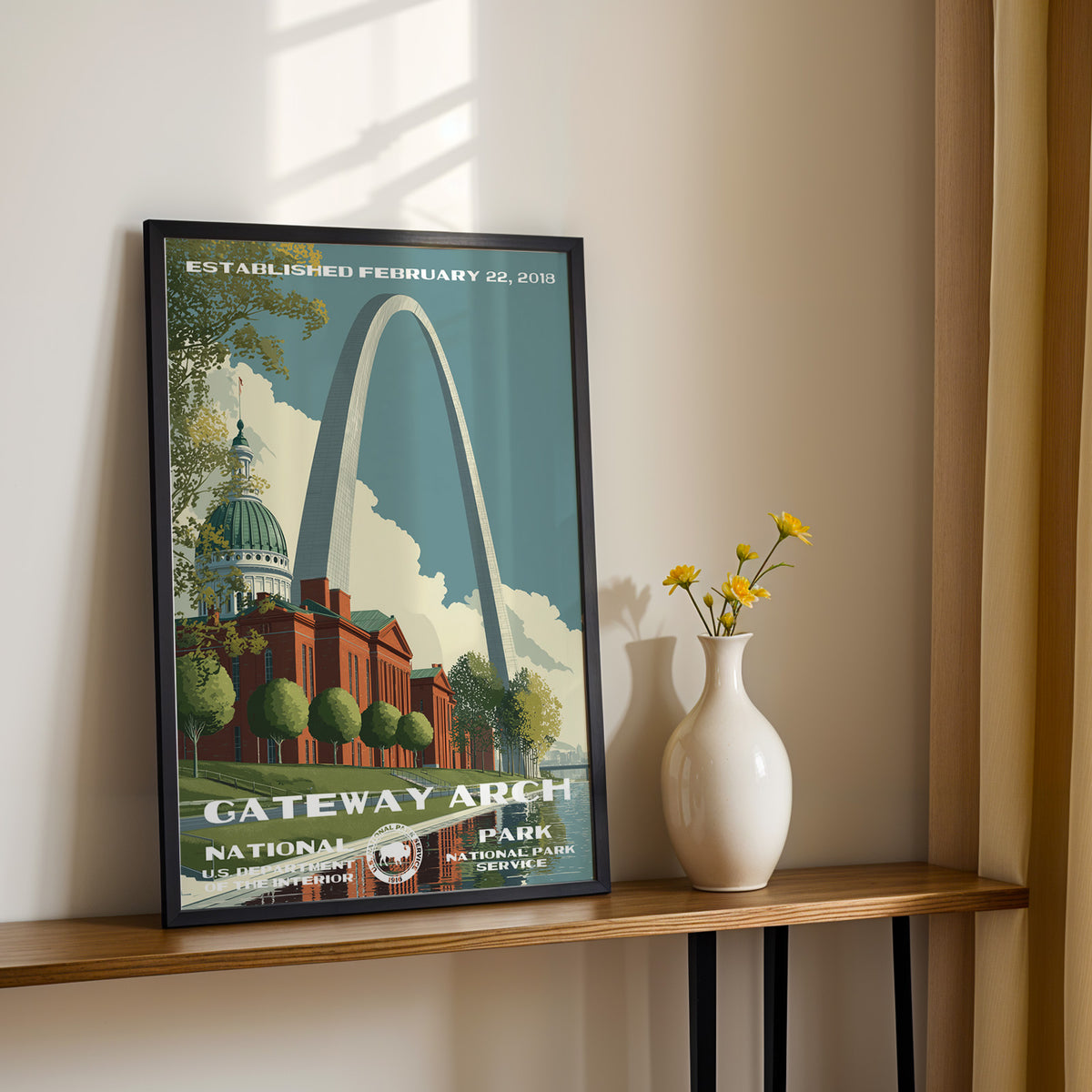 Gateway Arch National Park travel poster leaning on a console table with a vase of yellow flowers