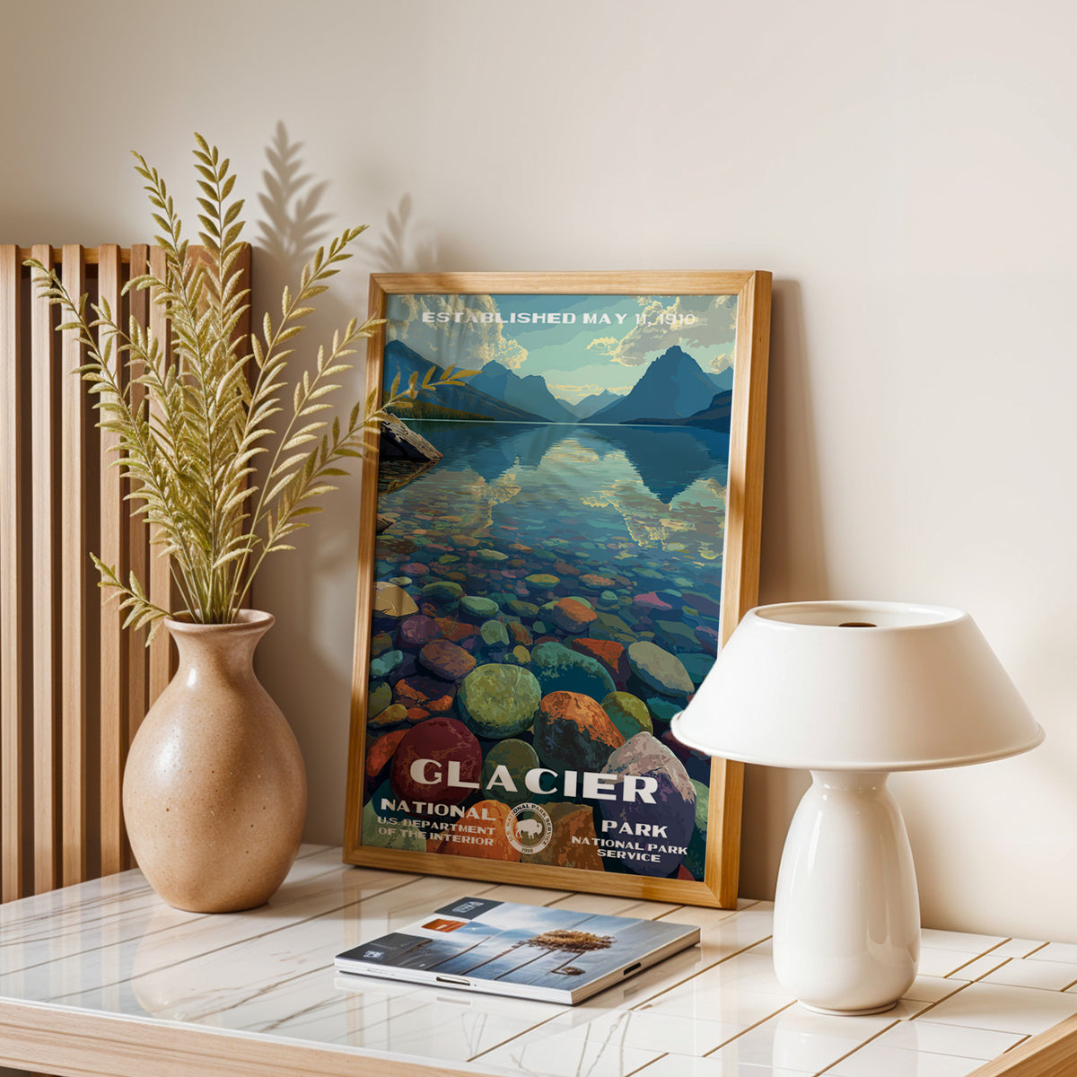 Glacier National Park vintage print leaning on a table with a ceramic lamp and dried grasses