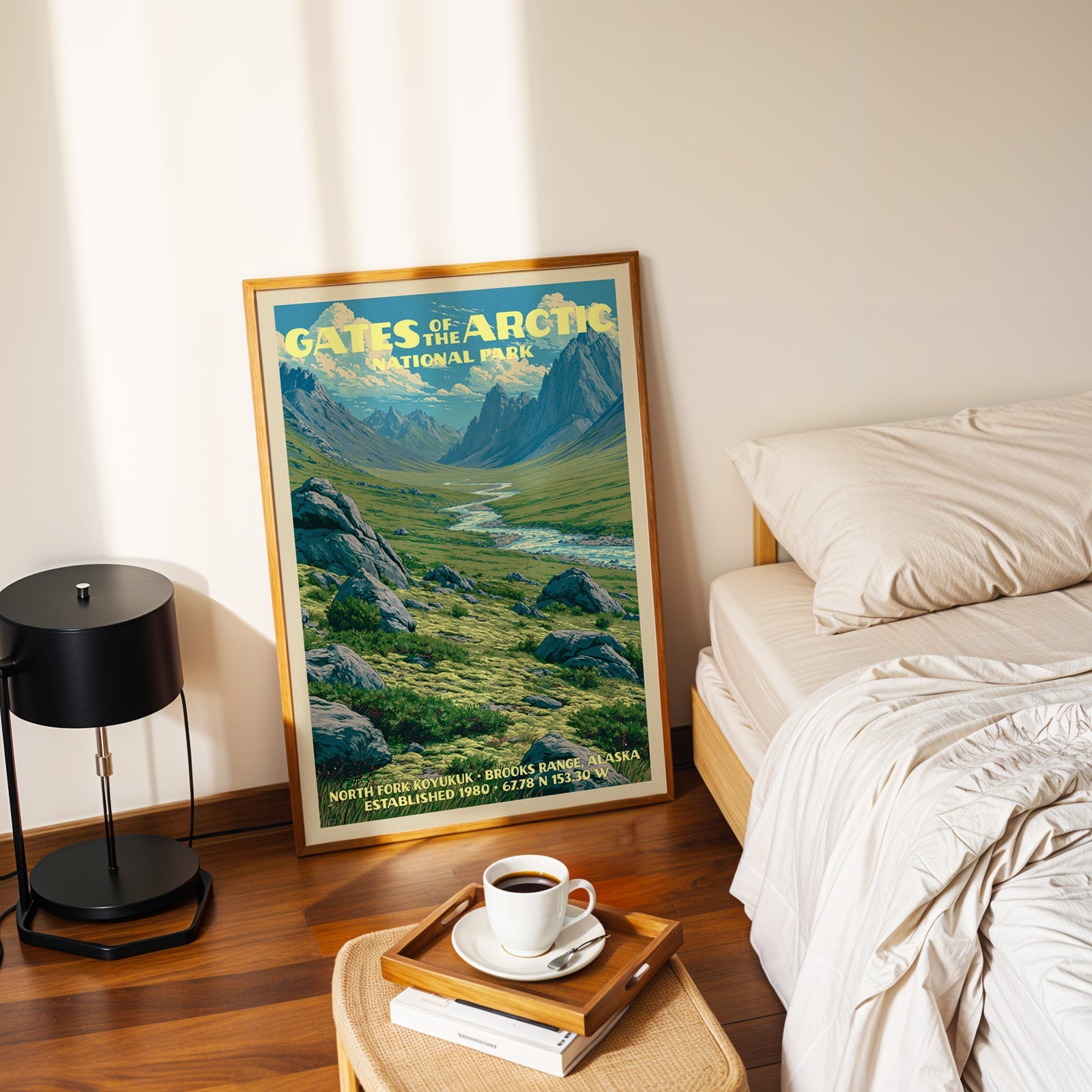 North Fork Koyukuk poster in a gold frame on the floor beside a made bed and a black table lamp
