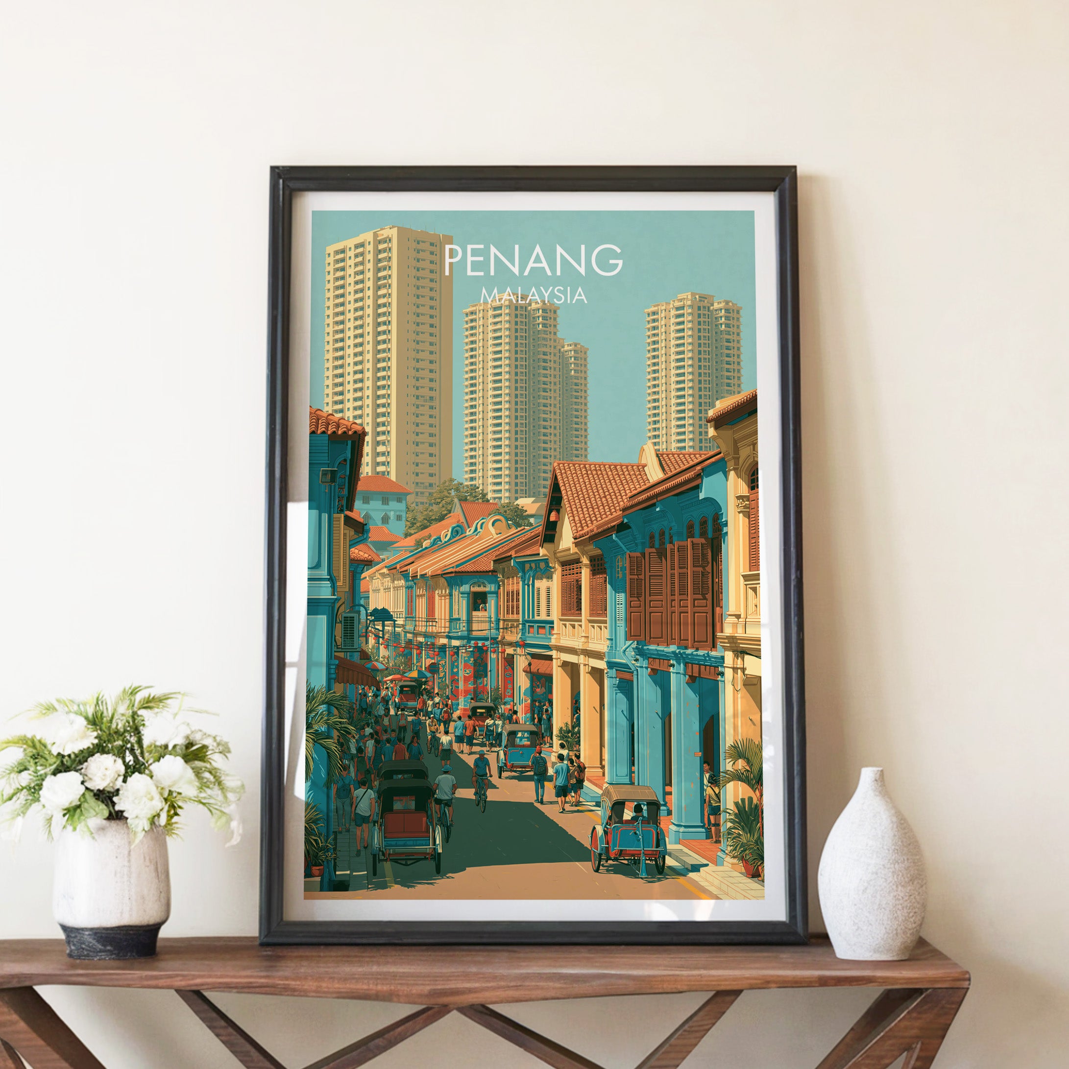 Georgetown Penang Malaysia travel poster in a black frame on a wooden console table with white flowers