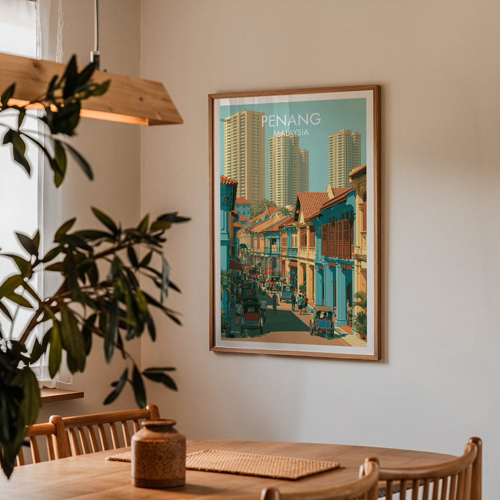 Framed Georgetown Penang Malaysia print on a dining room wall above an oak table in warm afternoon light