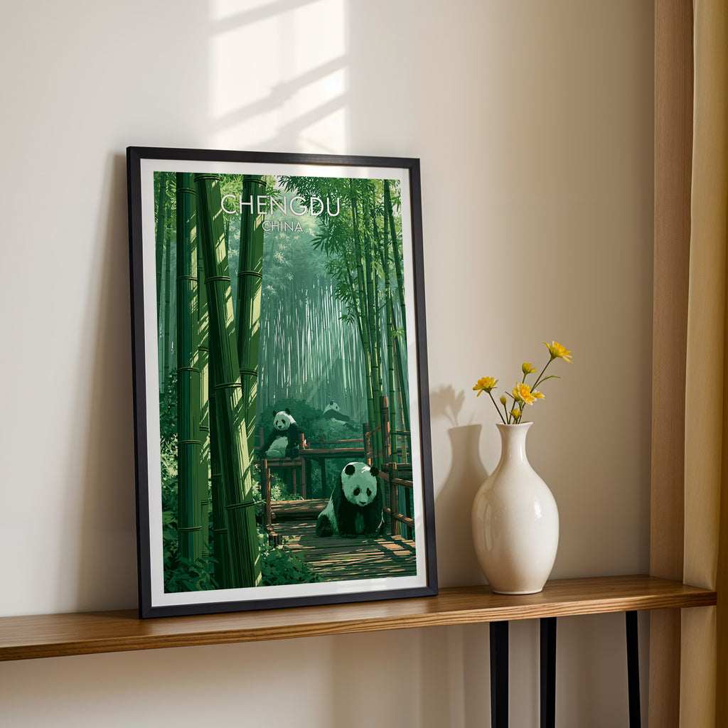 Black framed Giant Pandas Chengdu China print on a narrow hallway console in sunlight, styled with yellow flowers