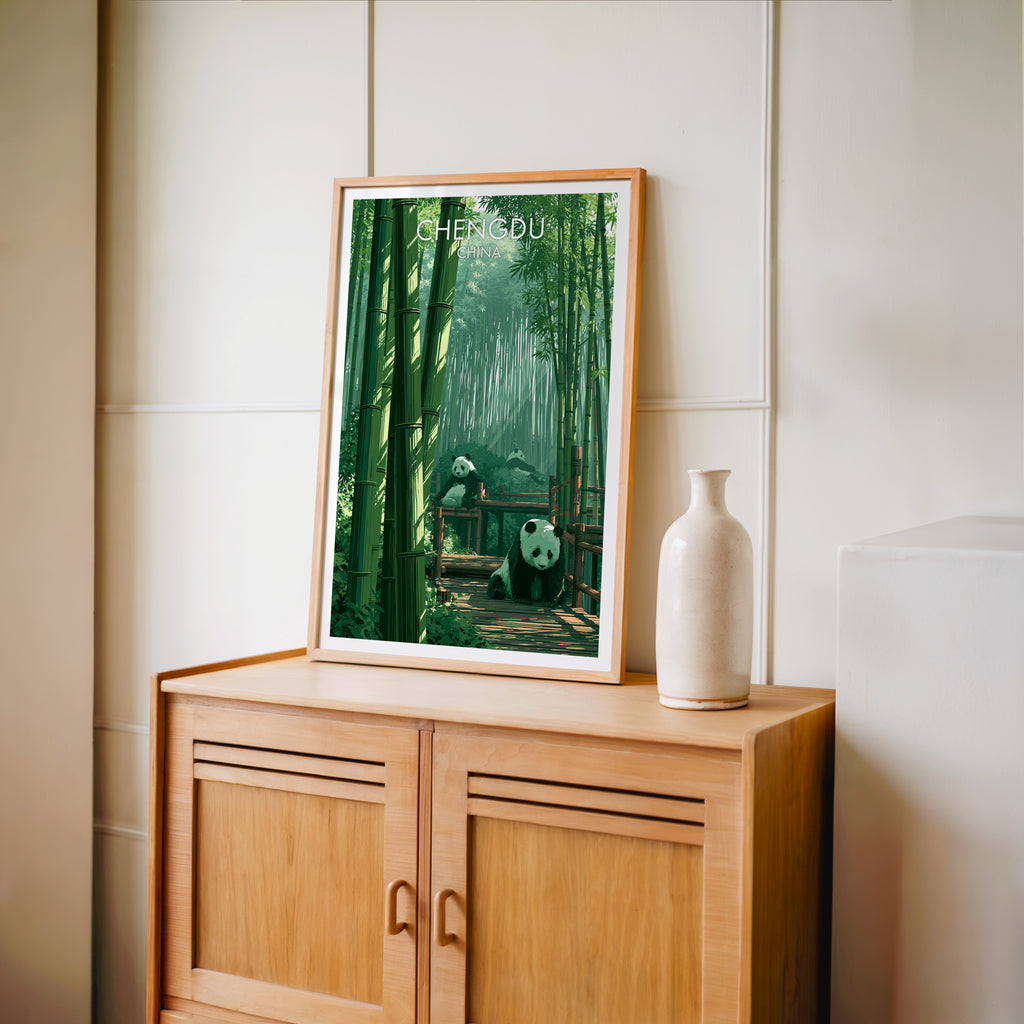 Small Giant Pandas Chengdu China travel poster in an oak frame on a mid-century sideboard with a ceramic vase