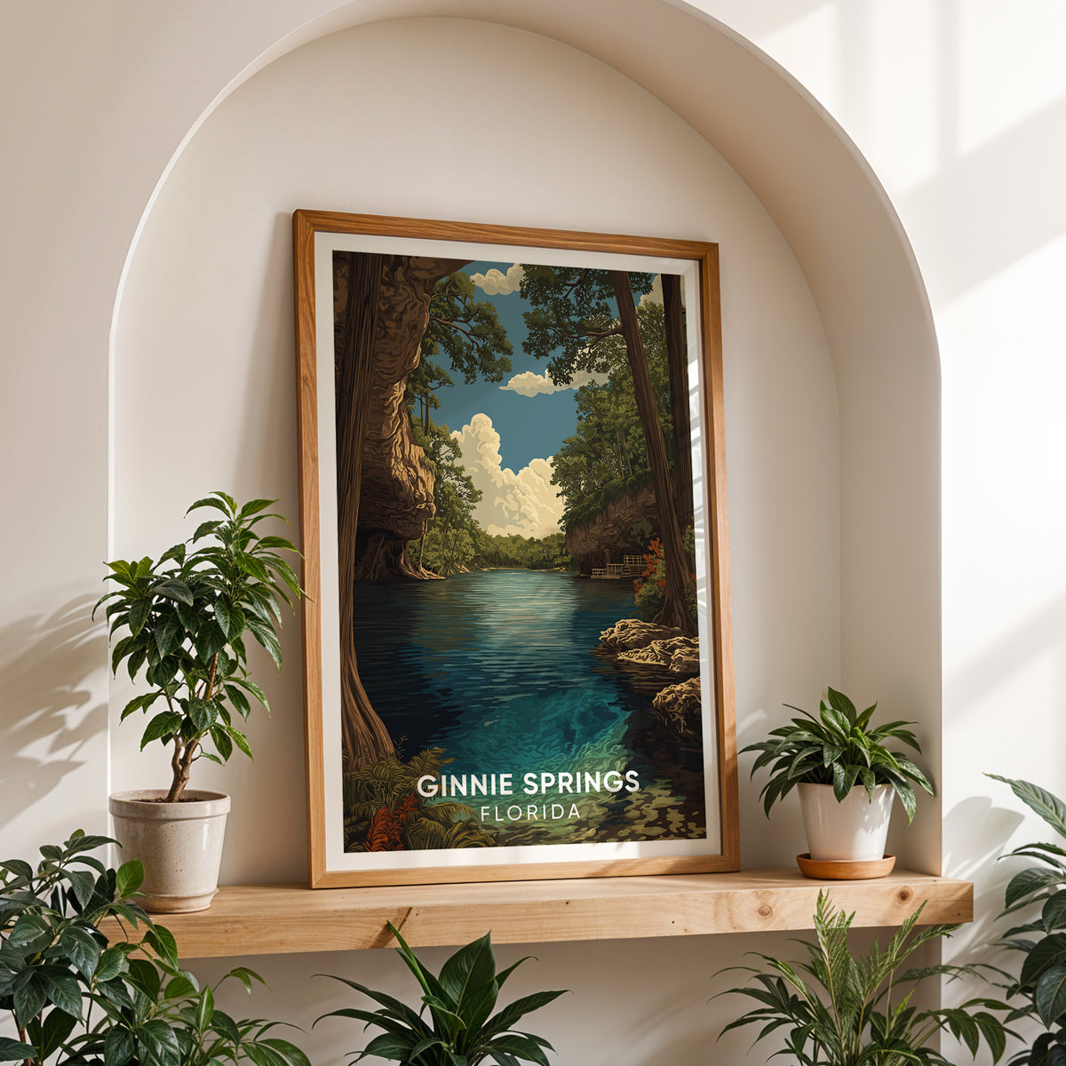 Ginnie Springs print on a wooden shelf inside a white arched alcove with a potted plant on each side