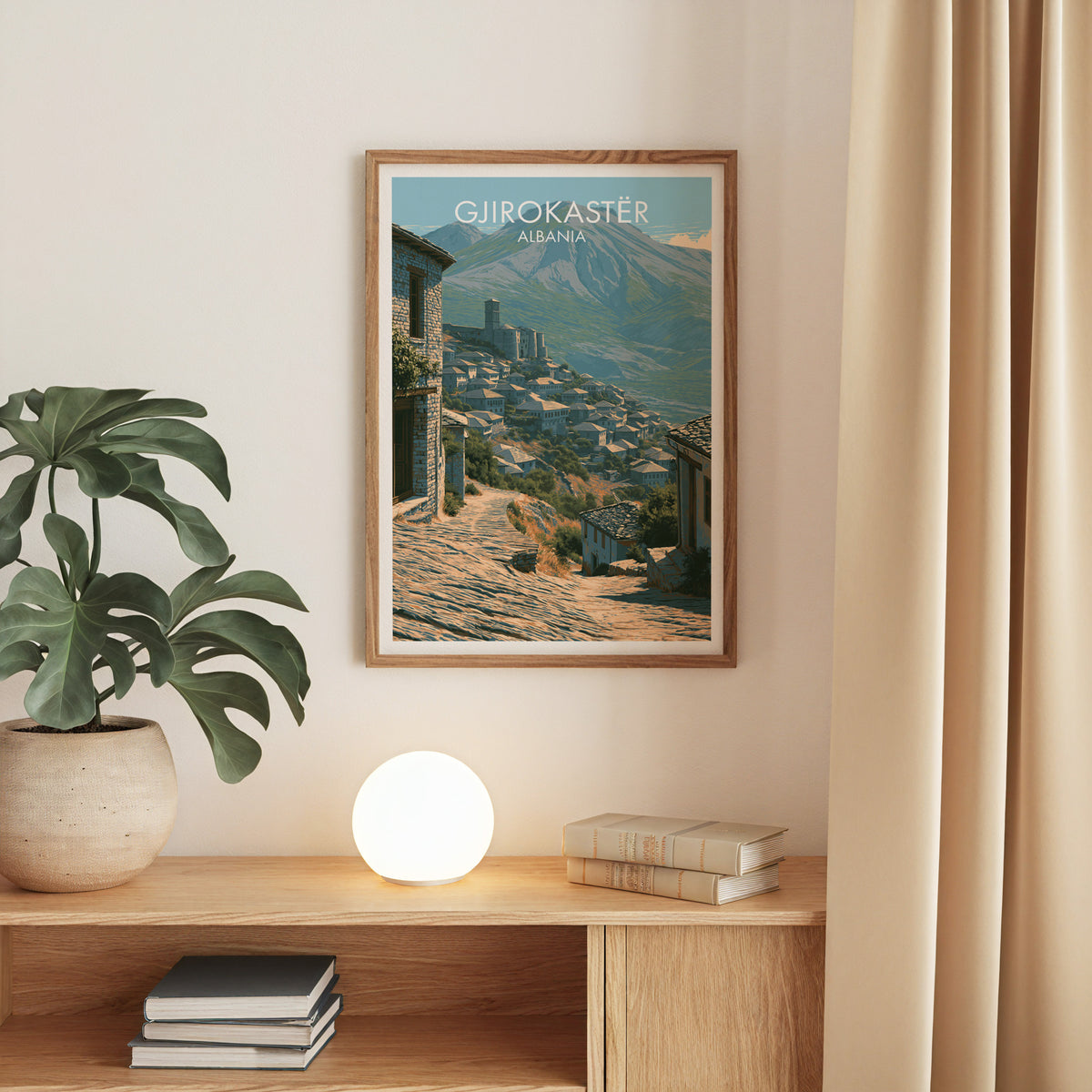 Gjirokaster stone roofs print, oak frame above an oak console with a monstera and a round globe lamp