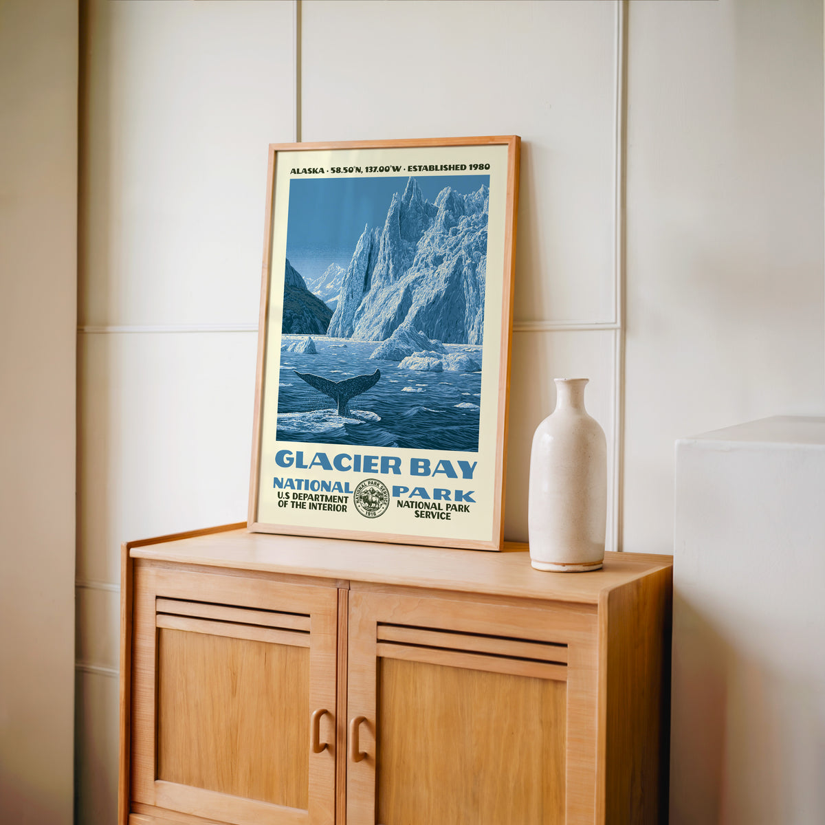 Glacier Bay National Park WPA print framed in light oak on a wooden sideboard with a ceramic vase