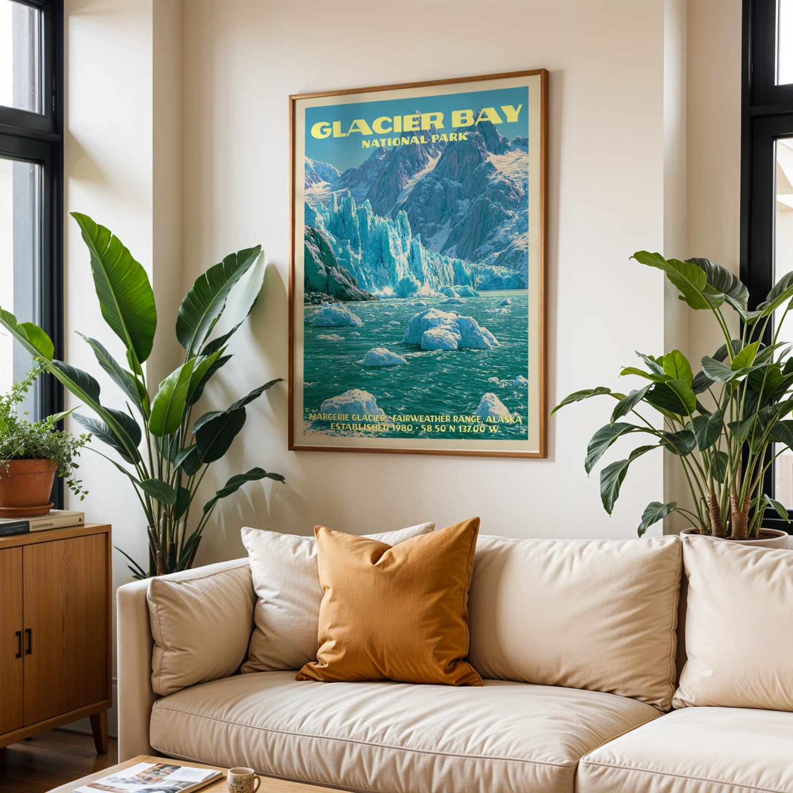 Glacier Bay vintage travel print in oak above a cream sofa with a rust cushion and tall tropical plants