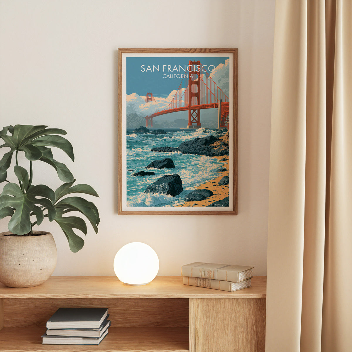 Golden Gate Bridge poster in an oak frame on a beige wall above an oak console with a monstera.