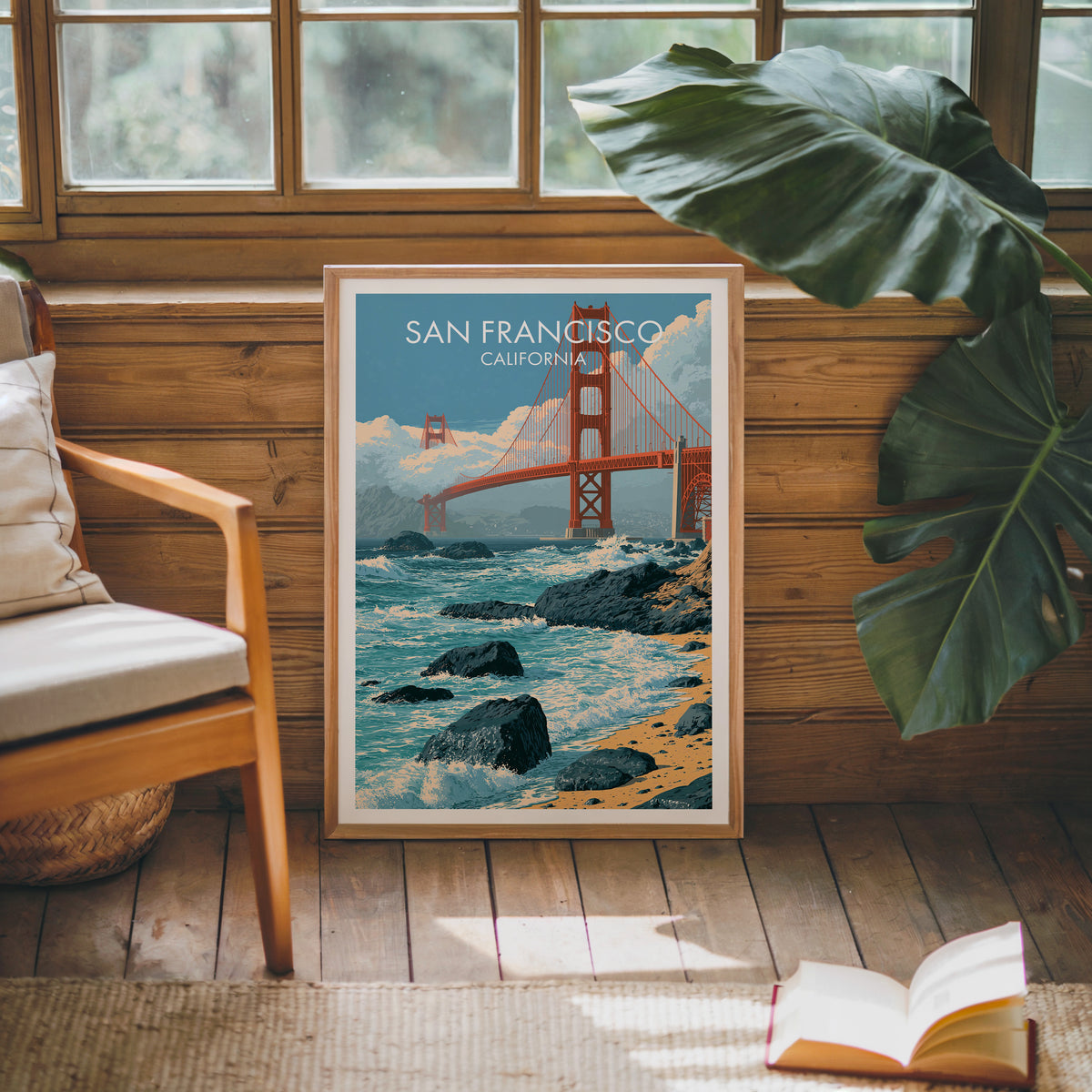 Golden Gate Bridge wall art in an oak frame on a sunlit wood wall by a mid-century armchair.
