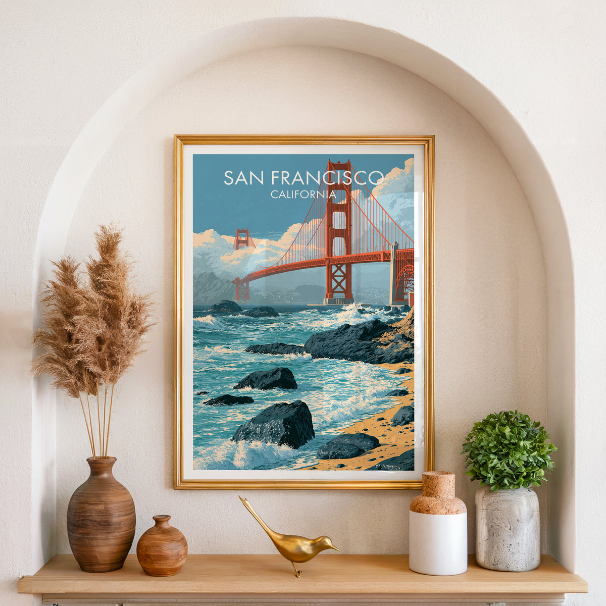 Golden Gate Bridge canvas art in a gold frame in an arched niche with pampas grass and a brass bird.