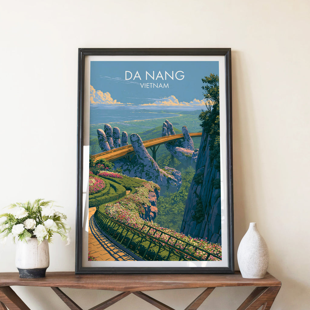 Golden Bridge Da Nang Vietnam travel poster in a black frame on a wooden console table with white flowers