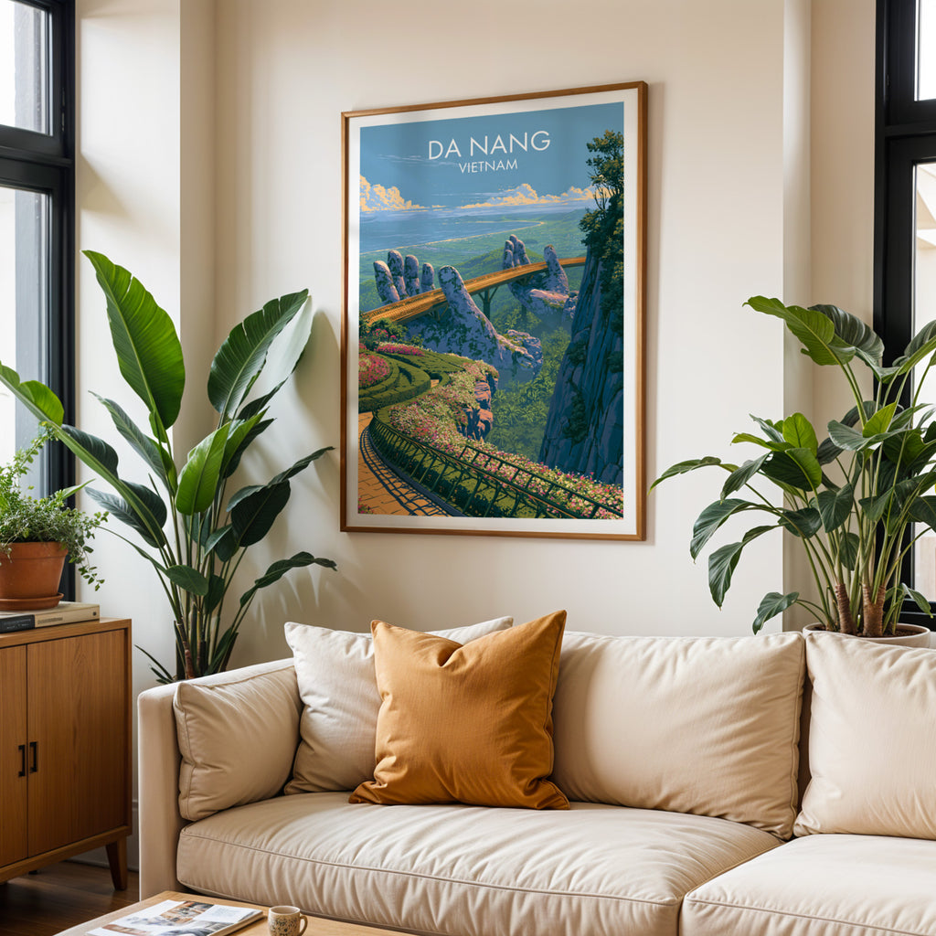 Framed Golden Bridge Da Nang Vietnam wall art hanging above a cream sofa in a bright living room with tropical plants