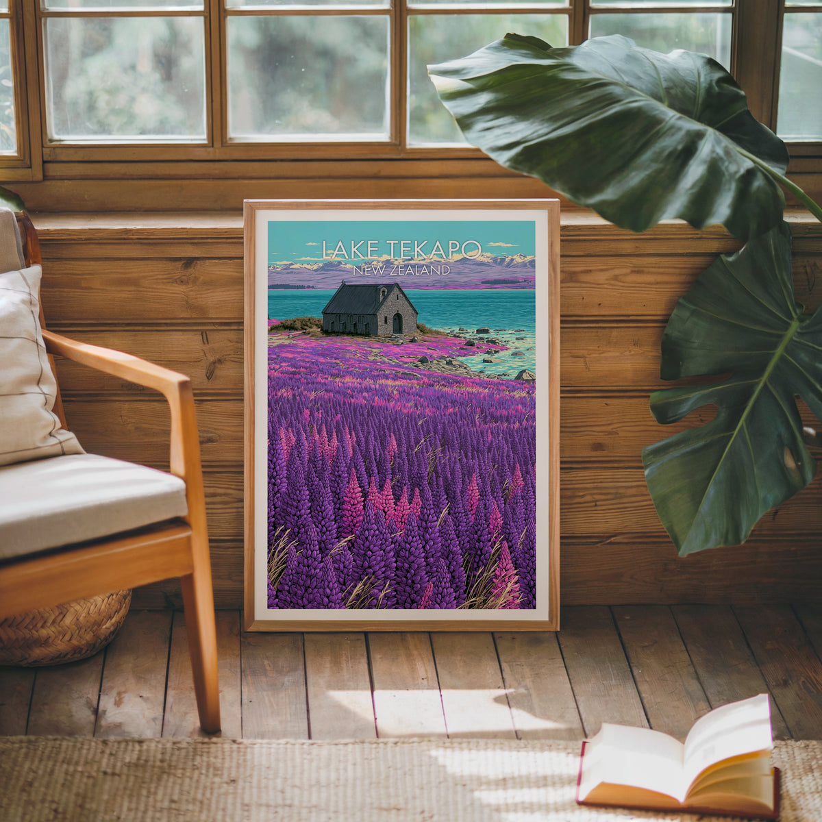 Oak-framed Tekapo print on a pine cabin wall with a wooden armchair and an open book on jute