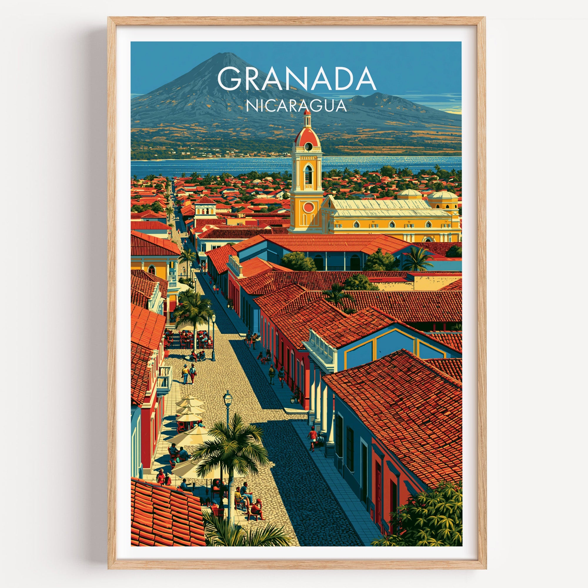 Granada Nicaragua travel print in a light oak frame on a plain white wall, red rooftops and a lake beyond