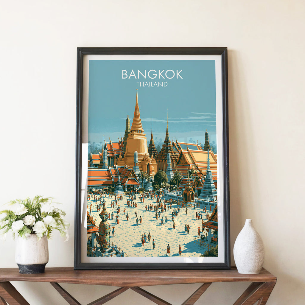 Grand Palace Bangkok Thailand travel poster in a black frame on a wooden console table with white flowers